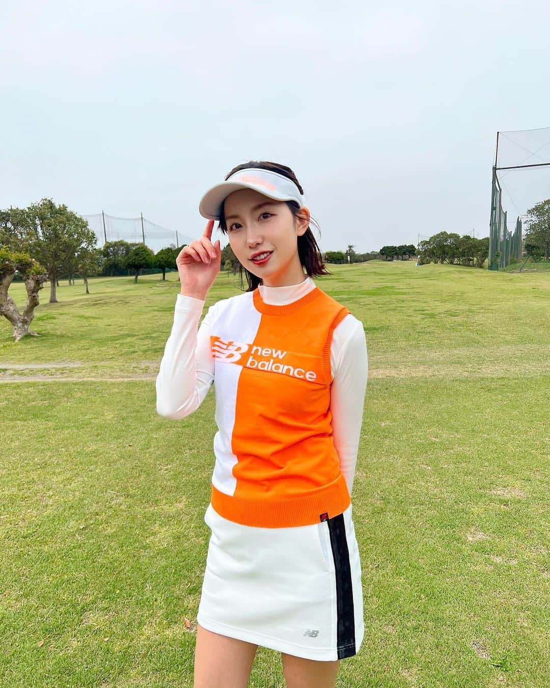 中島亜莉沙のインスタグラム：「どん曇りを吹き飛ばす ビタミンカラーコーデ⛳️🍊🤍  全身 @newbalancegolf_japan   ニットベストはハリのある素材で ゴルフ場で映えるカラーがお気に入り🧡 この時期に大活躍しそう‼︎  スカートはウエストがゴムで 履き心地がとても良き‼︎ バイザーはツバ長め✌🏻  みなさんゴルフの調子どうですか？🙋🏼‍♀️  #ろくまいめ #どっちが背高いかなあ  #ニューバランス #ニューバランスゴルフ #オレンジコーデ #ゴルフ #ゴルフウェア #ゴルフコーデ #スポーツウェア #ゴルフ女子 #スポーツ女子 #コーデ紹介 #春コーデ #newbalancegolf #golf #골프　#골프여자　#尔夫球 #高尔夫」