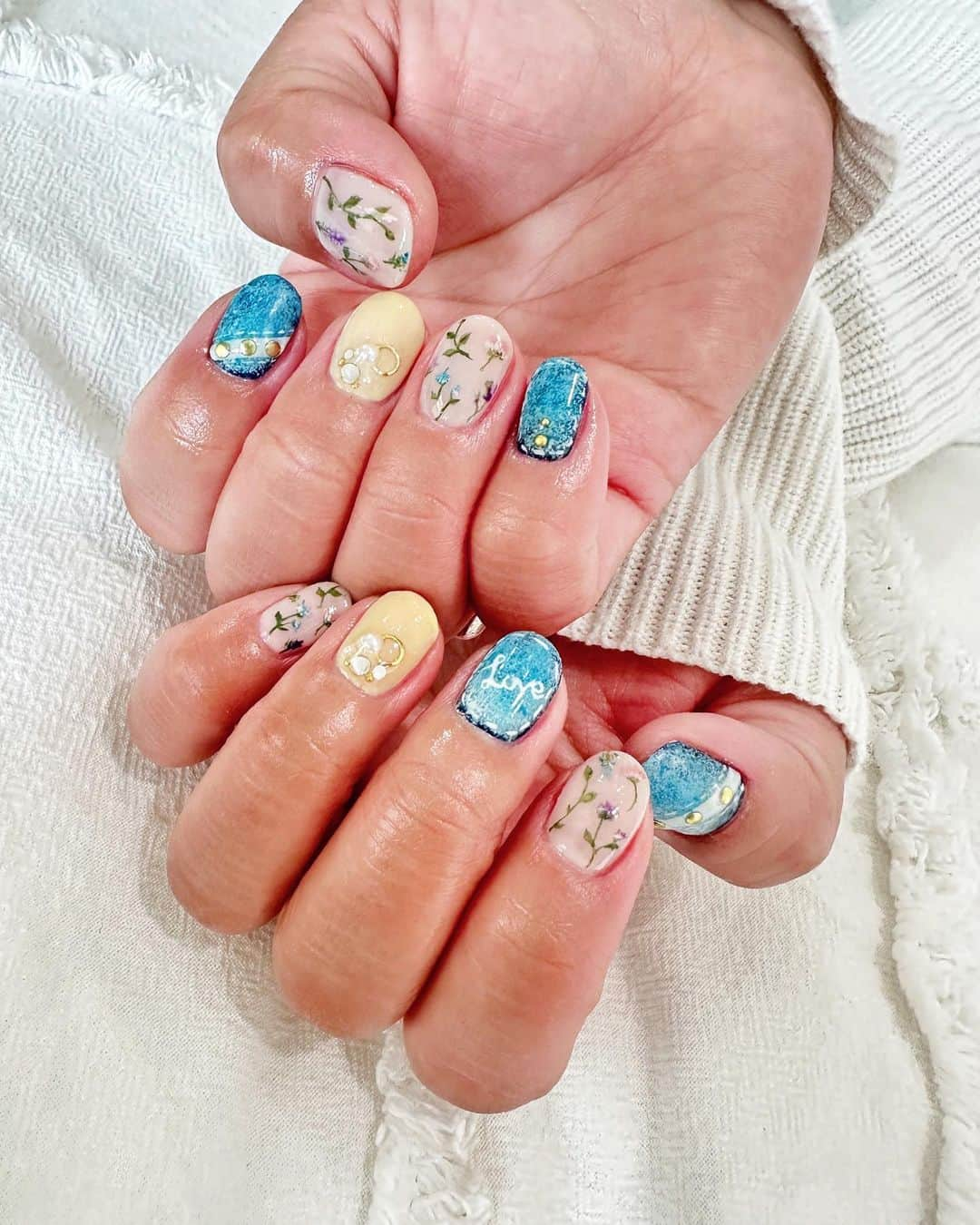 笠原美香のインスタグラム：「💅 暖かくなってくると パステル調の色味が人気♡  花柄って色んな種類があるんだけど これは春の薬草花って感じで落ちついた花柄と デニムの組み合わせがかわいいっ♡  自分でも、いやーよく描いたなぁ🫢って毎度思うんだけど 良くこんな小さいスペースに描けるよねwと  ネイリストってそんなもんなんだけどさ😂  2枚目は舐めたら甘そうなサクマドロップモチーフのネイル💅 3枚目はキラキラニュアンスネイル💅  #春ネイル #お客様ネイル#ネイリスト #アイリスト #ビューティスト #美容好き #ネイル #nail #シンプルネイル#ニュアンスネイル#クリアネイル #ビジューネイル  #ニュアンスネイル # #ビルダーネイル #セルフネイル #ネイル好き#押し花ネイル #花柄ネイル#フラワーネイル#キラキラネイル#手描きネイル#マーブルネイル#ドロップネイル#サクマドロップ#サクマドロップネイル#春ネイル#ssネイル#飴ネイル #キャンディーネイル #デニムネイル」