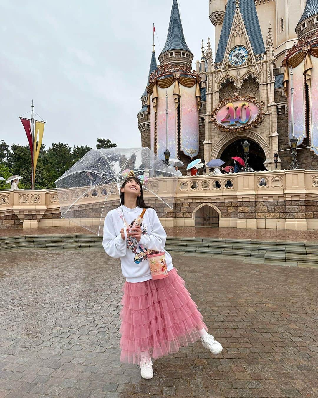 のインスタグラム：「#東京ディズニーリゾート40周年 🎉🌈 . . 昨日、4/15開園日記念当日は雨でも絶対に行く！と決めていて、行ってきました💗🫶🏻 . . 1日雨予報だったかはカジュアルに、でも春らしくピンクを纏いたい気分だった💗💐 . . 新しく発売されている #クレームブリュレ チュロスが気絶するほど美味しかった🥹🥹今まできなこチュロスが一番だったけどあっさり塗り替えられた！！！美味しすぎ！！！👏🏻✨ . . ミニーちゃんともグリできて、久しぶりに手握ってくれてお話できて😭😭😭感極まって涙出ました🥹🥹💗幸せな時間だった、、、！！！ . . . . 安定の雨だった4/15⭐️ 今年は晴れてる日に行ける機会が多いといいなぁ🥹🌈……… 雨の日の #ナイトフォールグロウ も素敵だけど🥹✨☔️ . . . . #disneyland #tokyodisneyland #tokyodisneyresort #tdr #tdl #disneyoutfit #disneyfashion #disneygram #disneyootd #ootd #outfitoftheday #ディズニーコーデ #ディズニーグラム #ディズニーランド #東京ディズニーランド #東京ディズニーリゾート #ディズニーフード #disneyfood #disneyfoodie #disneyfoodblog #ディズニーグルメ #限定メニュー」