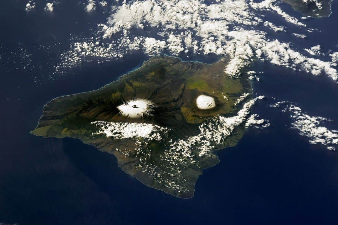 NASAさんのインスタグラム写真 - (NASAInstagram)「What happens when you combine lava and snow? A gorgeous image from the @ISS.  An astronaut snapped this picture over Hawaii of the snowcapped volcanos Mauna Kea and recently erupted Mauna Loa after a snowstorm covered the peaks. The image was taken last December after Mauna Loa’s nearly month-long eruption through November and December.   It’s not an uncommon sight, however. Winter brings Hawaii’s heaviest precipitation season, and these peaks both exceed 13,000 feet, so they’re no strangers to the snow.   Image Description: An aerial image of a green, nearly oval island, with a thick arm of the land jutting out to the left. Two volcanoes are close to the center of the island and can be made out by the contrasting white snow that covers the top of them. The rest of the island is varying shades of green, and the backdrop is a dark blue ocean. Clouds cover most of the top of the image and some of the bottom half of the island.  #NASA #Space #Earth #EarthFromSpace #Hawaii」4月18日 3時20分 - nasagoddard