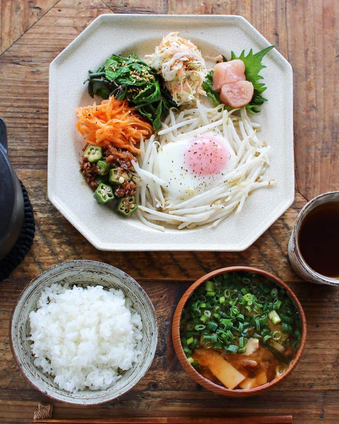 かおしのインスタグラム：「今日の朝ごはん。 久しぶりに#ラココットデゴハン でご飯を炊いたら、美味しすぎて1合食べちゃった🍚 おかずがヘルシーだから、いいよ…ね…？？🐷  ごはん、エリンギとキムチのお味噌汁、モヤシの巣篭もり卵、オクラの梅おかか和え、キャロットラペ、#コシアブラ の和えもの、コールスローサラダ、#粒だちたらこ (@taracosyokudo )、麦茶。  作り置きはしない派なんだけど、久しぶりに家時間が長い生活をしているといろいろ作ってしまい、食べきれず保存することになり、冷蔵庫の中がタッパーだらけになっている🙄 そういえば、昔おばあちゃんちの冷蔵庫を開けたら、いろんなおかずが入っていたな、と💭 それと同じ状態ですね、これは。  そして、#牛窓クラフト散歩 で買った#棚橋祐介 (@ochabatake.atelier )さんの八角皿の使いやすさがハンパない👏 適当に盛っても、整って見えるって素敵✨ うわー、これ予備でもう1枚買うべきだったー！ また出会えますように🙏  2日間のボランティア楽しかったなぁと、牛窓クラフト散歩の思い出に浸りながら過ごし中😌💭 ボランティアの副産物である全身の筋肉痛もまた、思い出のひとかけらとなっております🤭  #朝ごはん #朝食 #breakfast #ワンプレート #ワンプレートごはん #ワンプレート朝ごはん #私のおいしい写真 #和食 #japanesefood #おうちカフェ #川口武亮 #staub #foodporn #onthetable #foodstagram #暮らし #おうちごはん #instafood #うつわ #器 #wp_deli_japan #おうちごはんlover #IGersJP #フーディーテーブル #料理好きな人と繋がりたい」