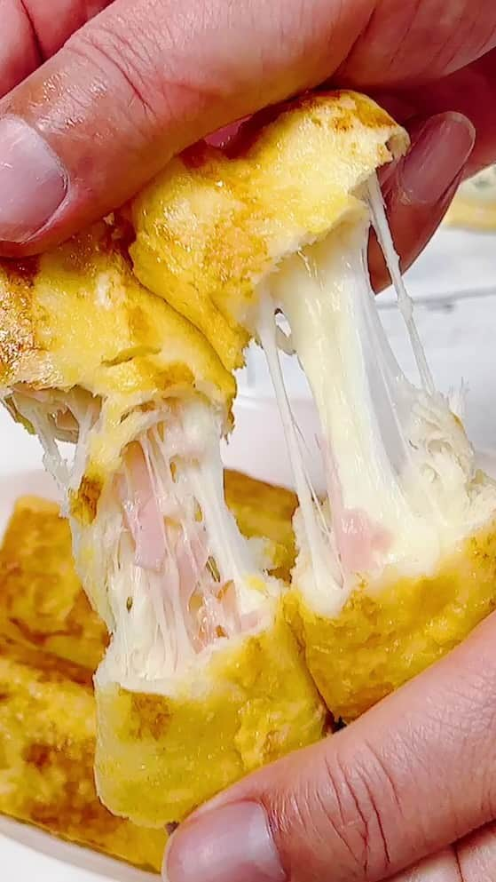 ひろまるのインスタグラム：「のび〜るチーズロールトースト cheese roll french toast  今回はSNSで話題のハムとチーズを巻いたパンに卵をつけて焼いたフレンチトーストです。 焼き立てを食べると熱々のチーズがのびて美味しいですよ。  This time, it's a French toast made with ham and cheese wrapped in an egg and baked.  【Ingredients】 4 sandwich bread 40g cheese for pizza 1 string cheese 2　Egg  10g salted butter   【材料】 サンドイッチ用食パン 4枚 ピザ用チーズ 40g さけるチーズ1本 卵　2個 有塩バター 10g   【作り方】 ①パンをめん棒で薄くのばす。  ②そこへピザ用チーズ、さけるチーズ、細く切ったロースハムを巻いてつまようじで止めます。  ③溶きほぐした卵に②を浸けてバターを敷いたフライパンで焼きます。  #パンレシピ #たまごレシピ #食パンアレンジ #サンドイッチ #フレンチトースト #朝ごはん #手作りおやつ #おやつの時間 #サンドイッチ弁当  #hiromarucooktv」