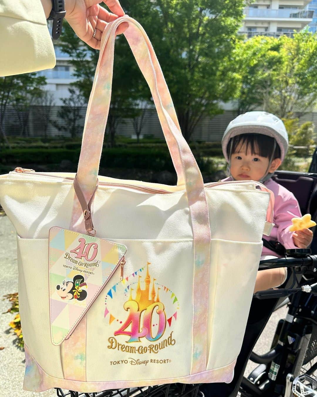 真麻のインスタグラム：「ディズニー行きました🥰1歳8ヶ月のデビュー👏たくさん歩くし、待ち時間にグズらないし、ミルクも離乳食もいらなくて快適でした✨やはりこのくらいのデビューで我が家は正解🙆‍♀️旦那とも話していて、うちは結果ベストなタイミングで行けて良かった💕旦那は3人目、私は2人目、と…まぁ幼きディズニーデビュー経験済みから今回はこのタイミングで✌️ベビーカーもB型に移行したり、娘の理解度もかなり2歳児に近くなってきて…親としても楽しめたよ❣️ ✩.*˚ 写真は旦那が見つけた40周年バッグ㊗️デカいかな？とも思ったけど、今まで使ってたのがいつもハミ出しててチャックもなしだったし(笑)ポケットも外側3ヶ所内ポケット2ヶ所あるし、めちゃマザーズバッグっぽい👀最高に使い勝手が良くて可愛いので、今後行くママさんにおすすめお土産ダントツです💓 ✩.*˚ 習い事の荷物入るし、自転車前カゴも入って文句なし〜✋3枚目は娘のスマイル😀スワイプ▶️📸 ✩.*˚ またディズニーデビューの投稿します✨色々バタバタしていて、投稿したいの溜まってる💦とりあえず、今日から3日連続で夜に予定あるから日中が勝負だぞ🔥早寝するとスッキリ‼️寝落ちじゃなく、本気の早寝も大事だね(￣▽￣)今日も頑張ろ💪 ✩.*˚ ✩.*˚ ✩.*˚ #ディズニーデビュー #1歳8ヶ月 #2人目育児 #ディズニー40周年グッズ #ディズニー40周年 #初ディズニー #良い子でした #娘は可愛い #育てやすい子 #アラサー育児 #不妊治療からの妊娠 #高齢出産ママ」