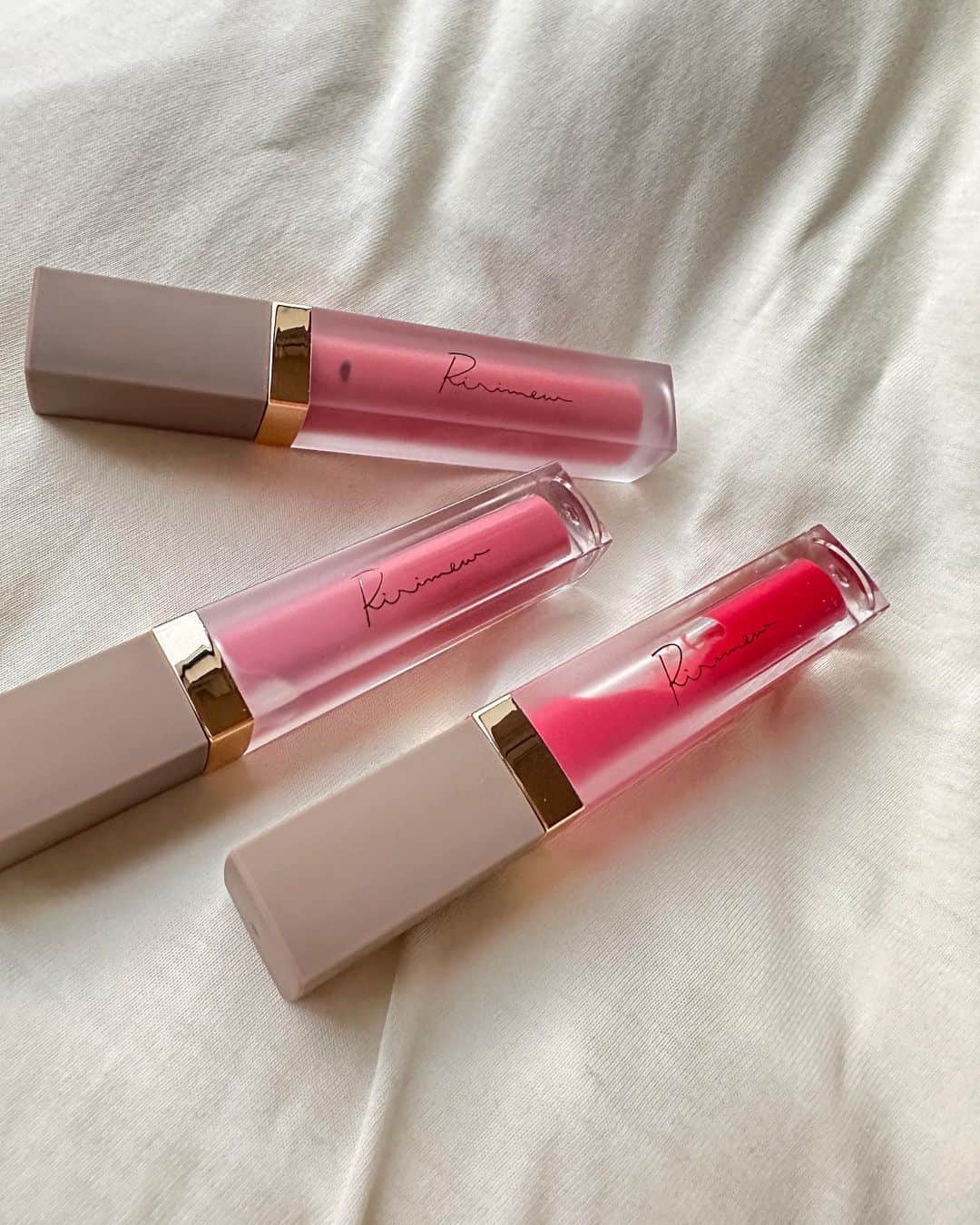 新井ニーニャのインスタグラム：「リリミュウの新作コスメ💄💕  4月21日(金)から公式サイト、ロフト、プラザ、＠cosmeTOKYOで発売開始だよ〜〜🌹 一安心先に、レポします❤️  今回の新色は06のピンクバター！ 名前の通り、少しこっくりしたカラーで 血色ピンクなのに、濃い感じ🫶  私は唇の中にほくろがあるんだけど 06をつけてるものだけ ほくろが目立たないぐらい こっくり色がのるよ🥰 ちなみにほくろの場所は、 上唇の山の左側🤣  02は上品で艶のあるピンクフォンデュ✨ パッと見た感じは06とあまり変わりないけど つけると質感も違うので、 好みのものを見つけられると思います💓  01のパピーレッドは 最近の赤リップでツボカラー！ 赤だけど春らしさのある明るめな色で 目立つ分ティントとしての効果もばっちりで この3つの中で色落ちしにくいものだと思います🫢❤️  イエベさんは、ツボると思います🌹  #PR、#Ririmew、#リリミュウ、#新作コスメ、#コスメレポ、#リップ、#ティントリップ  @ririmew_official」