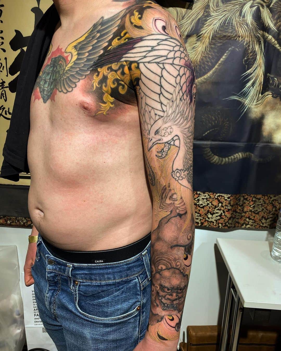 SHIGEのインスタグラム：「In progress work at @godsofinktattooconvention ,Actually I started this piece was in London 19’ Continued more lines, and started some colors,, Thank you! @padzimmermann  Otsukarrsama deshita!  #shige #shigetattoo #shigeyellowblaze #yellowblazetattoo #黄炎 #鳳凰 #唐獅子 #houou #karajishi #japanesetattoo #japaneseart @bishoprotary #bishoprotary #bishopfamily @inkeeze #inkeeze #dipcaps @dipcaps @davincineedles @fusionink #fusionink #fusioninkproteam #godsofinktattooconvention #frankfurt」