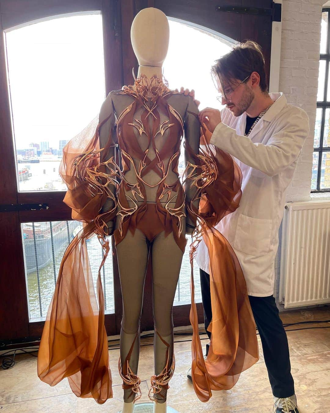 Iris Van Herpeさんのインスタグラム写真 - (Iris Van HerpeInstagram)「Inside the atelier ~ hand stitches are being done on the organza drapes of the Singularity jumpsuit.   The body embellishments are sustainably 3D-printed using left-over Cocoa shell beans, to then be electroplated with copper.  #irisvanherpen #hautecouture」4月21日 1時00分 - irisvanherpen