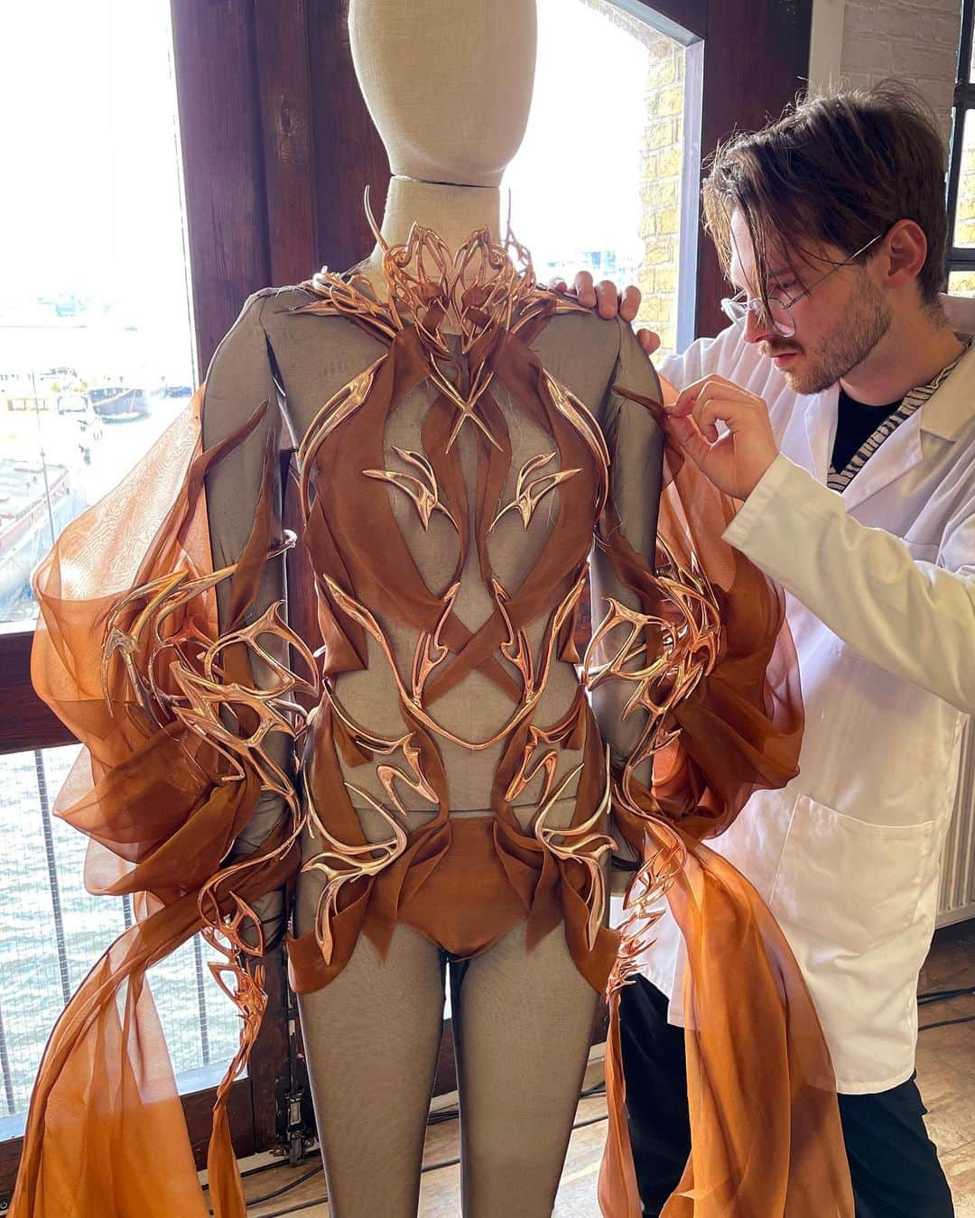 Iris Van Herpeさんのインスタグラム写真 - (Iris Van HerpeInstagram)「Inside the atelier ~ hand stitches are being done on the organza drapes of the Singularity jumpsuit.   The body embellishments are sustainably 3D-printed using left-over Cocoa shell beans, to then be electroplated with copper.  #irisvanherpen #hautecouture」4月21日 1時00分 - irisvanherpen