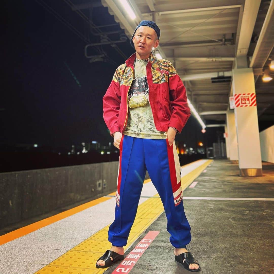 市川刺身さんのインスタグラム写真 - (市川刺身Instagram)「今日の服装。 幕張3ステの日。 合間に大自然ロジャーさんの沖縄そばナポリタン美味しかった。 気持ちいい風。  ハラノムシで購入したシルクスクリーンが決まってるTシャツに掃除会社ダスキンのジャケット。 十四才で購入したrunningのジャージ。 JAのキャップに黒の便所サンダルで足をケア首から金のがま口を下げて。  ライブ終わりに幕張豊砂の駅でアイロンヘッドの辻井さんに撮っていただきました。 文句ありそうな顔をしてしまって反省ですが流石SNSフリークの辻井さん電車来る前にスピーディーに撮ってくれました。 辻井さんありがとうございます。  #今日着た服 #ファッション #古着 #ハラノムシ #十四才 #便所サンダル #幕張豊砂  #アイロンヘッド #辻井さん劇場宿泊してた #そんでめっちゃ食ってた」4月20日 20時52分 - soitsudoitsu