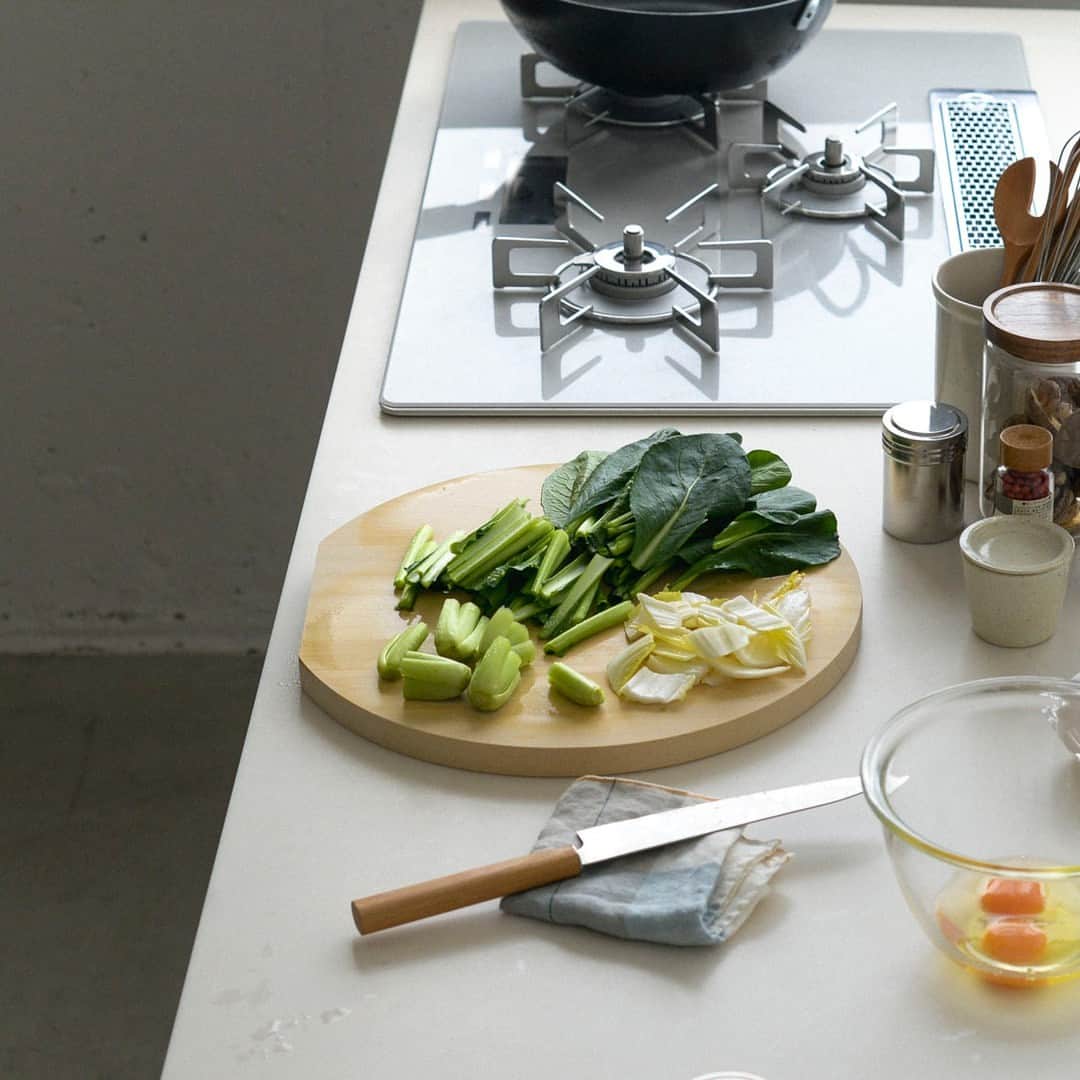 北欧、暮らしの道具店さんのインスタグラム写真 - (北欧、暮らしの道具店Instagram)「この形だからこそ、便利なんです！ 料理がスムーズになる「丸いまな板」 . - - - - - - - - - - - -  できることならスムーズに済ませたい、 忙しい毎日のご飯づくり。 だからこそ、キッチンの上をもっと効率よく 使えたら……と思うのです。  こちらの「丸いまな板」は、 バイヤーが実際に使ってみて、 その便利さに惚れ込んだアイテム。  「丸型」の魅力は、角がないこと。 角がない分、台所道具や調味料・食材を まな板にギュッと近づけて置け、 作業台の省スペースが叶うんです。  さらに、丸型だから、くるっと回すだけで、 まな板の空いているスペースが正面に。 そのため、まな板の隅々までを使って 食材を切ることができます。  切った食材を上に置いたままにしても、 邪魔になりにくいのもポイント。 肉じゃがや豚汁など、 具だくさんな料理も もっと作りやすくなりそう。  サイズは全部で3種類。  「小サイズ」 玉ねぎや、フルーツがまるっと。 コンパクトなキッチンやサブまな板におすすめ。  「中サイズ」 ほうれん草や、小松菜がまるっと。 一人暮らしから家族づかいまで幅広くおすすめ。  「大サイズ」 白菜やキャベツも、まるっと。 ゆったり使いたい方におすすめ。  使ってみたら、丸いからこその 使い心地の良さのとりこになった、 このまな板。  一枚迎えてみたならば、 きっと日々のご飯づくりがもっと気楽に、 たのしいものになりそうです。 . ーーー 掲載のアイテムはこちら▼ ーーー . ☑︎ 梅沢木材工芸社 / 青森ひばの丸まな板 - - - - - - - - - - - - - - - - - -   ▶︎ お買いものはプロフィールのリンクから ご覧くださいね。→@hokuoh_kurashi . #kitchen#kitchendesign#kitchenware#food#foodstagram #まな板#カッティングボード #キッチン#キッチン雑貨#キッチングッズ#台所 #ごはん#朝ごはん#ランチ#夜ごはん#ディナー#料理 #シンプル#シンプルライフ#シンプルデザイン #暮らしを楽しむ#日々の暮らし#北欧#暮らし#北欧暮らしの道具店」4月20日 21時01分 - hokuoh_kurashi