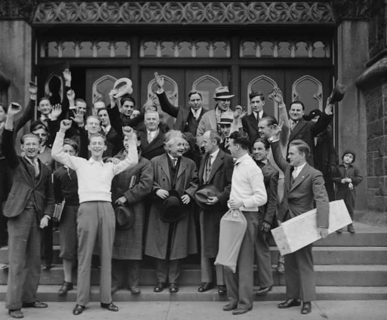 アルベルト・アインシュタインのインスタグラム：「#ThrowbackThursday: Einstein was presented with a silver cup, awarded each year to the person who received the highest poll in the vote of the four thousand students at Northeast High School in Philadelphia. This photo from Jan. 1934 shows Einstein receiving a round of cheers as he left the school after the presentation.」