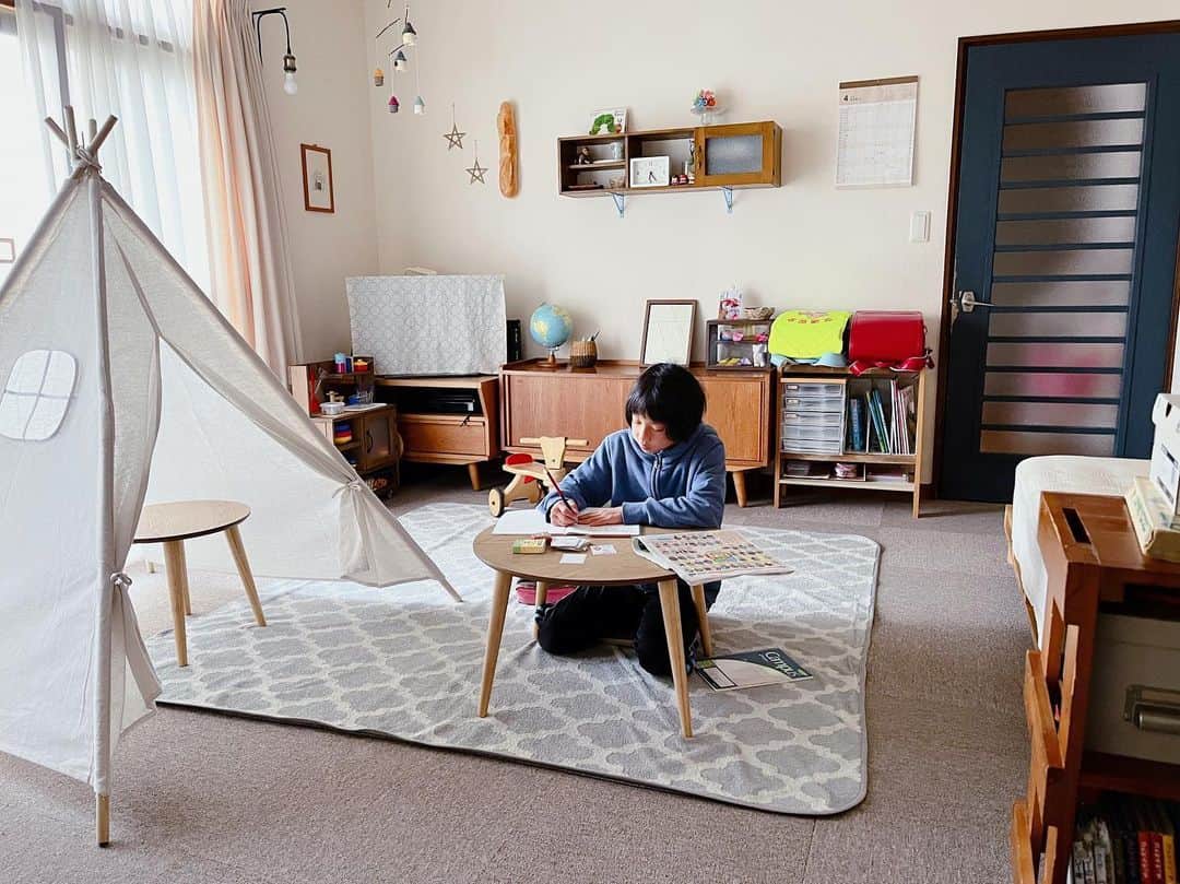 トテンのインスタグラム：「気の迷いだと思っていた、たまちゃんの朝学習が続いています。本日の起床5:15…⏰(母さんに一人時間をくれ)  焼き鮭入りの小さなおにぎりをあげたらペロリと食べて、今日は県庁所在地を覚えていました🗾  気分により、つむちゃんの小さなテントの中にいます⛺️  新一年生のつむちゃんも本格的？に授業が始まったので、準備がしやすいようにランドセルや教科書ノート類はリビングに場所を作りました。  100均で購入したA4の引き出しは、学校のおたより入れです。子供たちが日々、それぞれ自分の場所に分けて入れます。  横のAVボードを開けると、文房具類✏️✂️📐やノート📔のストックがあります。  とっ散らかるたび収納はあれこれ工夫してみるものの、それでも日々とっ散らかる無限の悩みです🤯🤯🤯」