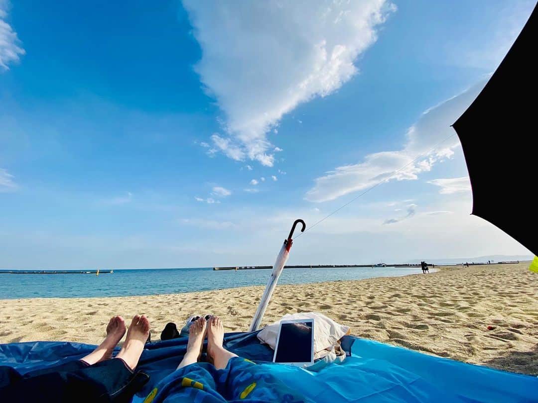 平松愛理のインスタグラム：「⁡ 須磨海岸2023パラソルデビュー🏖 なぜビニール傘が？ よ〜くご覧ください👀 パラソルへと繋がってる一本の糸を… ⁡ iPadでBillboard70's Hitsを聴きながら、寄せる波ゆく波、大空、水平線眺めました🌊☀️ ⁡ もうひとつの足🦶は須磨で生まれ育った同級生の。 ⁡ ⁡ #須磨海岸 #同級生」