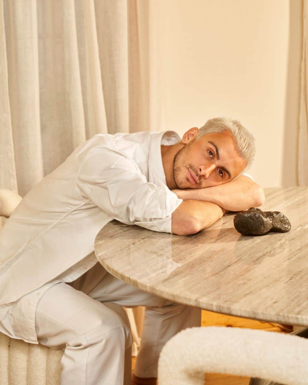 New York Times Fashionのインスタグラム：「Christian Cowan is known for designing raucous, gleeful clothing that has been worn by celebrities like Lady Gaga, Cardi B and Lil Nas X. The designer himself, however, is all about the quiet life.  @christiancowan, a Londoner settled in New York City, made his name by confecting the vibrantly colorful sequined and feathered club wear that is catnip to the party crowd. He is also linked with the pop star Sam Smith, a fellow Brit. Their frequent outings have given rise to speculation that they are an item.  Given all that exposure, some may find it perplexing that Cowan is tight-lipped about the relationship, with talk of his private life strictly off limits. He maintains that when he isn’t in his SoHo studio, he leads a cloistered life, listening to jazz, watching television documentaries and “seeing what the James Webb Space Telescope is up to,” he said in an interview with The New York Times.  Manhattan suited him as the ideal place to cultivate and promote his label. Just over a year ago, Cowan opened his first store, on Wooster Street in SoHo, as a temporary showcase for his extravagant designs, its powder pink interior flirting with camp without forfeiting a sense of opulence.  “I wanted to be here, to be this brand that Upper East Siders feel fabulous wearing, as much as Lower East Side club kids,” he said.  Read @ruthlaferla’s full profile of Christian Cowan at the link in bio. Photo by @sethdcaplan」