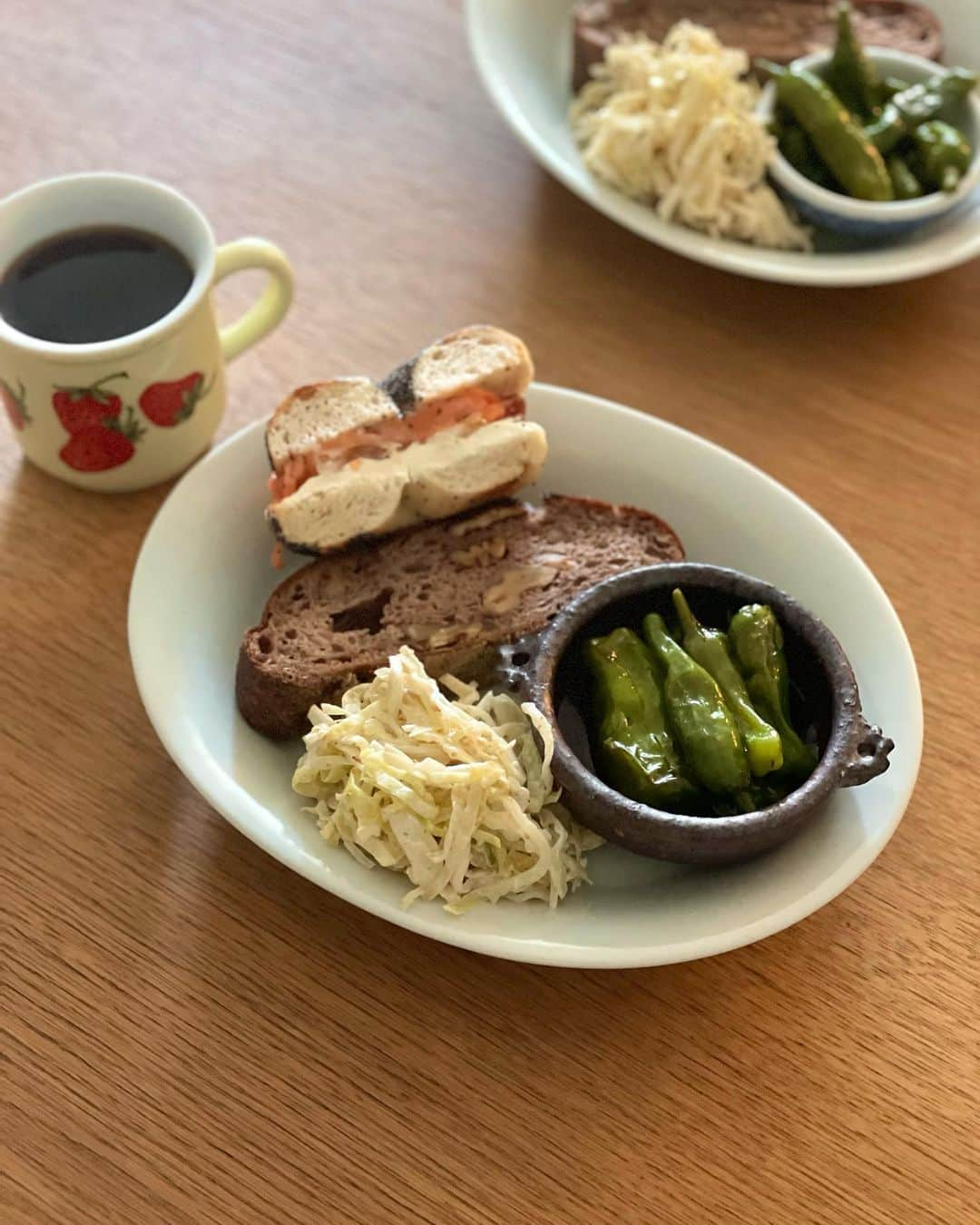 冨田ただすけのインスタグラム：「今日のお昼ごはんは、弁当の残りの和風コールスロー、ししとう焼き浸し、 @kiso_nagoya さんのパン。  最近はいちごのマグカップの出番が多い🍓  #お弁当の残り #白ごはんドットコム」