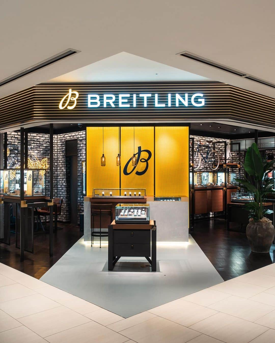 #ぶらエディターズ GINZA SIX オフィシャルのインスタグラム：「BREITLING BOUTIQUE TOKYO 5F @breitling_ginzasix_squad   日本の商業施設では初となるブライトリングのブティックが、3/25（土）GINZA SIX 5Fにオープンしました✨⌚️ブライトリングとは1884年に設立されたスイスの時計メーカーで、近代のクロノグラフ機構を開発したり、ナビゲーションツールウオッチのパイオニアとしても知られています🇨🇭👏🏻   そんな革新的なメーカーの時計がフルコレクションで揃うのが、BREITLING BOUTIQUE TOKYO（ブライトリング ブティック トウキョウ・📸1枚目）です🙌🏻店頭には、陸、海、空のそれぞれのシーンで活躍するモダンレトロなスタイルの時計が、常時150本以上も並びます！   ブティックに入ったらまず注目したいのが、入口すぐのショーケースです（📸2枚目）✨陳列されているのはブランドのアイコン的な時計、ナビタイマーの最新モデル。中でもナビタイマー B01 クロノグラフ 41のアイスブルーのダイヤル（📸3枚目・税込1,160,500円）は特に人気で、実物を見られるブティックが限られているそう👀💫見つけたら要チェックです✍️✅   ほかにも品格漂うプレミエ コレクション（📸4枚目・プレミエ B01 クロノグラフ 42 税込1,100,000円）やフォード マスタングやシェルビー コブラなど往年のアメリカ車からインスピレーションを得て作られたトップタイム クラシックカーズ（📸5枚目・トップタイム B01 シボレーコルベット 税込990,000円）など、発表間もないモデルも見逃せません！✨   さらに世界でもわずか数店舗、国内ではここだけとなるアパレルも販売（📸6枚目）😳👕！これはオーストラリアのブランド、デウス・エクス・マキナ @deusresidenceとのコラボレーションによって生まれたもの。デウス・エクス・マキナはハンドビルトのカスタムバイクやパーツの販売にはじまり、サーフィンやスノーボード、自転車、音楽などさまざまなカルチャーにまつわるアパレルアイテムを展開するブランドです🏄🌴🏂☃️🗻   ブライトリング ブティック トウキョウには、タイポグラフィが背面に描かれたブライトリングカラーのイエローのTシャツ（📸7枚目・税込9,900円）や、両ブランドのロゴマークが並ぶキャップ（📸8枚目・税込5,500円）など、リラックスして着られそうなアパレルアイテムがズラリ👏🏻   内装は全世界のブティックと同様に、インダストリアル・ロフトと呼ばれるブランドの最新デザインコンセプトで彩られています（📹9枚目）。レンガ倉庫のような空間にヴィンテージ風のペンダントランプ、味わい深いオリジナルの什器、クラシカルな自転車などを巧みに配したモダンレトロな雰囲気は、まるで大人の隠れ家のよう☺️   さらに路面店と違ってドアがなくて間口が広いので、開放的で立ち寄りやすい佇まいも魅力。実際ふらっと入店する人も多く、中に入るとブライトリングに精通したブランド公認のスペシャリストたちが迎えてくれます。中でも森祐二店長（📸10枚目）はウオッチコーディネーターの資格を持つ時計販売のスペシャリスト😳✨ブライトリングについてはもちろん、時計の歴史や技術的なことなど幅広い知識を備えた、頼れる方なのです🙋🏻‍♂️❣️   ブライトリングの魅力について森店長はこう話します。「1940年代〜’80年代にすでに完成されたデザインを、さらに現代の技術でブラッシュアップしたモデルが多く、ヴィンテージウオッチの雰囲気を最新のキャリバー（ムーブメント）で味わえます。しかもキャリバーの多くが自社製で、シースルーバックと呼ばれる透明な裏蓋を採用しているモデルがほとんど。複雑でメカニカルなキャリバーの動きを眺めて楽しめることもポイントです」   長く使う時計だからこそ、充実したアフターサービスはブランドの要でもあります✨同じ銀座の4丁目には、サービスセンターであるスタジオ ブライトリング銀座があり、ベテランの時計修理技能士たちが修理やメインテナンスを行ってくれるので、安心して預けられるのも嬉しい点です😊🙌🏻   現在、ブライトリング ブティック トウキョウでは時計を試着した腕元をInstagramにアップすると、ギフトがもらえるイベントを不定期で開催中。今後もこうしたイベントを増やしていき、さらに盛り上げていきたいと話す森店長🙋🏻‍♂️🌟気負わず入れるブライトリング ブティックで、ブランドの世界観や時計の魅力に触れてみましょう！   ―― 5F ☎03-4588-6484 ――   #ブライトリング #東京 #銀座 #腕時計 #breitling #watch #ウォッチ #japan #swiss  #swissmade #squadonamission #land #sea #air #空 #陸 #海 #pilot #diver #deus #デウス #deusexmachina #navitimer #ナビタイマー #ginza #ginzasix #ギンザシックス   @ginzasix_official」