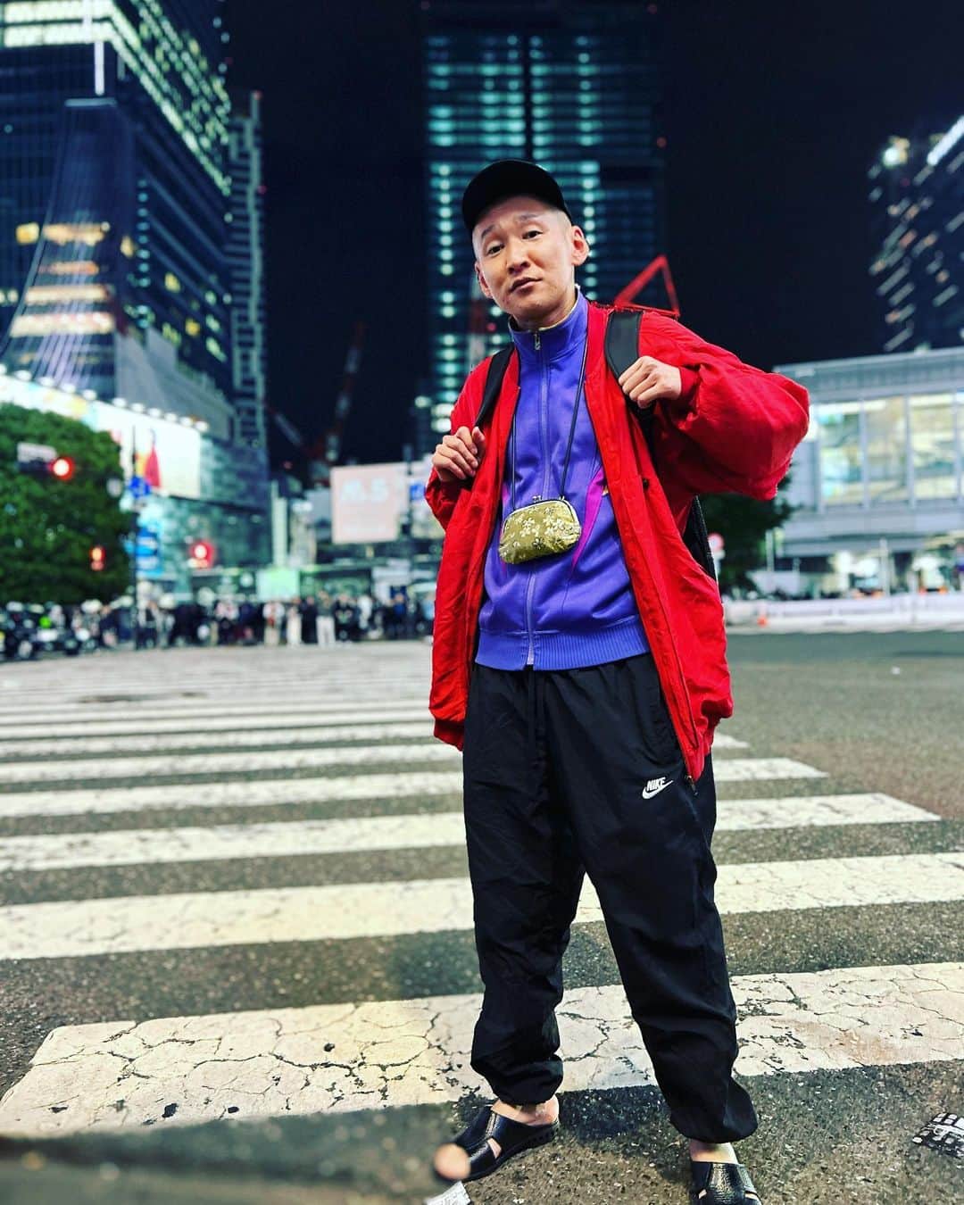 市川刺身さんのインスタグラム写真 - (市川刺身Instagram)「今日の服装。 渋谷無限大ホールで5ステ疲れ果て。 食べたら眠くなると思って1日グミしか食べてない。  昨日に比べて温度が下がるとの予報を受けロンTにasicsのBEZAのジャージに赤のジャケットを。 5ステに耐えれるリラックスさを求めてNIKEの黒シャカシャカ。 疲れた足を黒の便所サンダルが包み込みdos monosの帽子mont-bellの透けてるリュックに金のがま口。  ライブ終わり片付け済ませてカゲヤマさんとの帰り道スクランブル交差点でタバやん。さんに撮ってもらいました。 凄い人がいる渋谷でこんなチャンス中々ないので恥ずかしさは微塵もありませんでした。 タバやん。さん観ててくれた益田さんありがとうございます。  #今日着た服 #ファッション #古着 #渋谷 #無限大ホール #何も食ってない #明日早起き #頑張れ自分」4月23日 0時04分 - soitsudoitsu