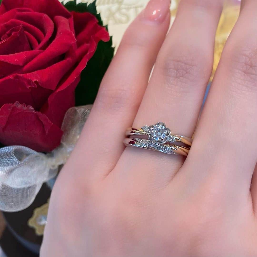 JKプラネット銀座.表参道.福岡|結婚指輪セレクトショップのインスタグラム：「~ ディズニー 美女と野獣《期間・数量限定モデル》~ 🌹 -6th season-Be with You (ビー・ウィズ・ユー) 🌹  ”真実の愛”を象徴する魔法の薔薇。時間がたつにつれて花びらが儚く散っていくと共に少しずつ中を深め、愛が芽生え始めていく2人・・・ 様々な困難を乗り越え、2人の真実の愛に気付きます🤍 花びらが散ってゆく様子をエンゲージリングに、そして2人の気持ちが通じあっていく様子をマリッジリングに。 2人の思い合う気持ちを３色のマテリアルで表現した6th season限定の特別なデザインです✨  リング内側には「美女と野獣」オリジナル刻印をお入れできます。好きなキャラクターやモチーフを組み合わせておふたりだけの特別なメッセージを♡  --＊--＊--＊--＊--＊--＊--＊ JKPLANET（@jkplanet.jewelry）全店にて取り扱いです。 ⇩JKPLANET  SHOP LIST⇩ 銀座本店・銀座2丁目店・表参道店・横浜元町店・大宮店・名古屋栄店・福岡天神店・熊本上通店・宮崎橘通り店・鹿児島天文館店 --＊--＊--＊--＊--＊--＊--＊  #JKPLANET #JKプラネット #結婚指輪のセレクトショップ  #美女と野獣 #ローズドーム #ディズニー #disney #disneywedding #ディズニー婚 #ディズニーウェディング #ディズニープリンセス #ディズニー好きな人と繋がりたい  #結婚指輪  #マリッジリング  #婚約指輪 #エンゲージリング #ダイヤモンド #ウェディング #ブライダルリング #プロポーズ #婚約しました #結婚指輪探し #婚約指輪探し  #結婚指輪💍 #婚約指輪と重ね付け　 #前撮り #フォトウエディング  #入籍 #入籍しました #weddingring」