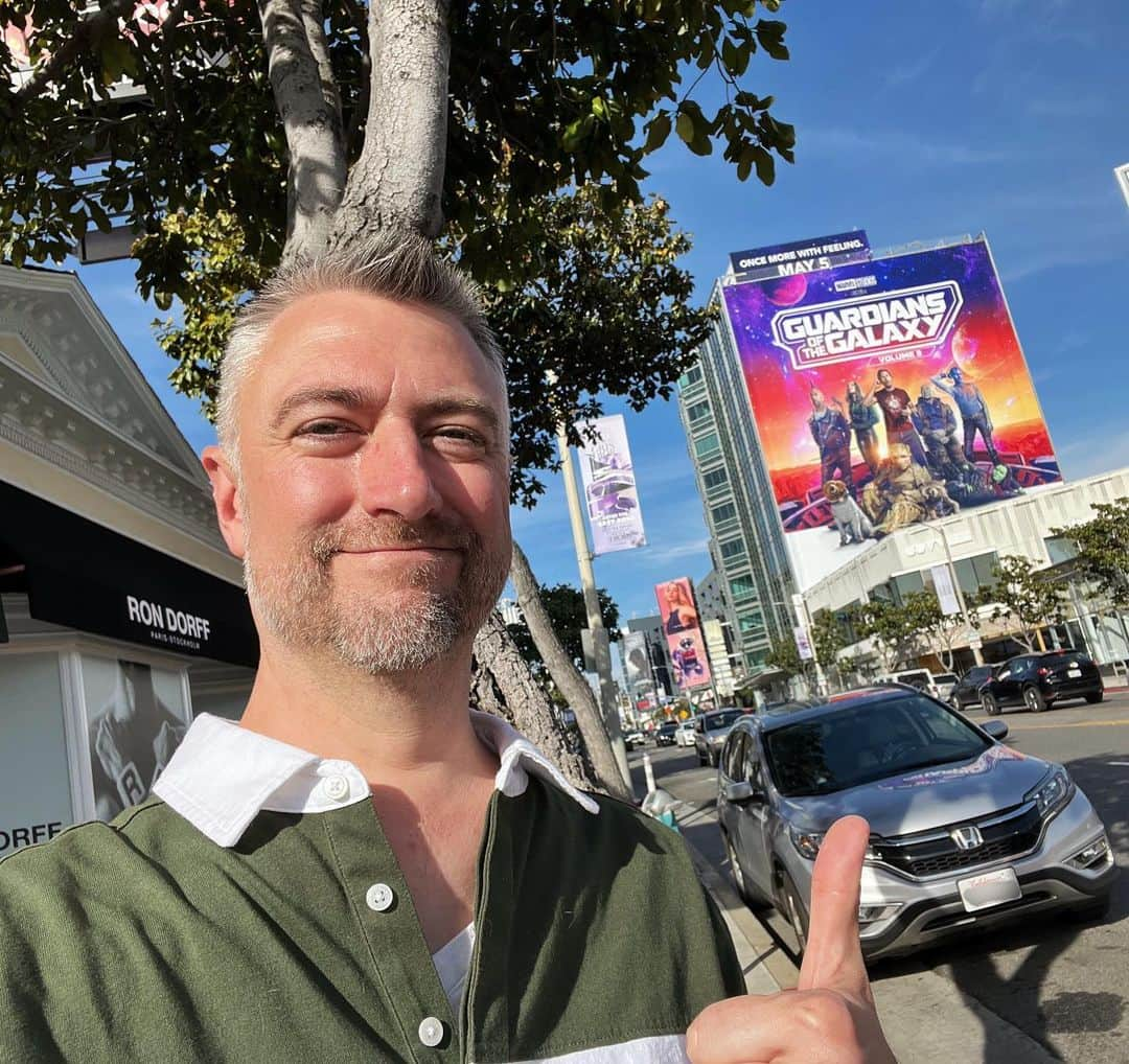 ショーン・ガンのインスタグラム：「When I moved to Hollywood in October of 1997, I remember my brother Brian pointing out this building: “whatever you see here is always the next big movie coming out”. It stuck with me.  I never get too excited about things I’ve done in my career because I know it can disappear quickly (I’ve seen it happen many times), and also, I remember hearing a story about the great Walter Payton advising a rookie: “don’t celebrate too much when you get to the end zone, because it will seem like you won’t be back there again.” And I took that to heart.  So anyway, here I am on the “next big movie” building. And after 26 years, forgive me if I spike the ball with a little extra gusto. That’s me up there!   (Oh, and that isn’t an Orloni on my shoulder, it’s on a stick and Mantis is eating it 🤷🏻)  #guardiansofthegalaxyvol3 in theaters everywhere 5/5!」