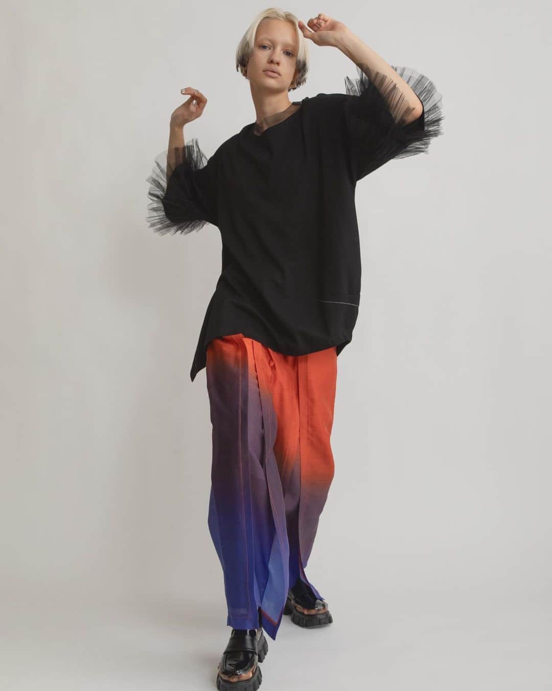 AULA AILAのインスタグラム：「【2023 HIGH SUMMER COLLECTION】  TULLE FRILL SLEEVE T-SHIRT COLOR BLACK SIZE 0 ¥16,500  チュールを3段フリルにした、ビックシルエットのTシャツです。  ハリのある同色チュールがボリュームたっぷりで、目を引くデザイン。  見頃は透けないコットンスムースを使用し、右裾が長くスリット開き、左脇はコクーンシルエットのアシンメトリーなオーバーサイズ。  リラックス感とフェミニンなチュールフリルのミックス感が絶妙なアイテムです。   GRADATION PANTS COLOR ORANGE SIZE 0 ¥23,100  裾から3段にオリジナルグラデーションプリントした、目を惹くパンツ。 シルクのような滑らかさと微光沢のある生地は、涼しくてとても軽く、シワになりにくいのも嬉しいポイント。  フロントは大胆なスリットになっていて、内側にパンツがレイヤードされています。 動くとスリットが開くデザインが、軽やかでアクティブ。 ウエストベルトの後ろのみゴム入りなので、締め付けられないノンストレスです。   ✔️AULA AILA OFFICIAL WEB STOREにて HIGH SUMMER COLLECTIONアイテム展開中！」