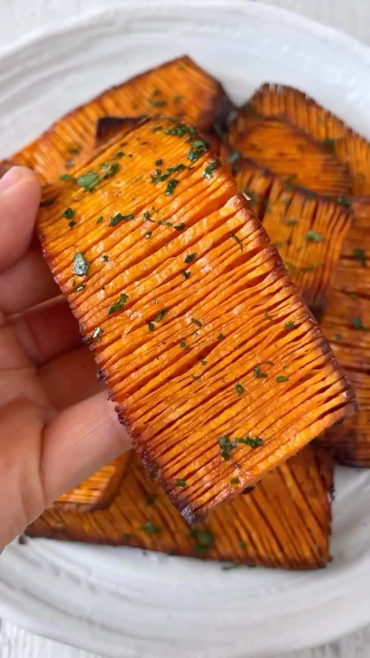 Sharing Healthy Snack Ideasのインスタグラム：「Accordion Sweet Potatoes 🍠✨ by • @thrivingonplants Serves: 2  Time: Way too long (lol)  Ingredients 4 medium sweet potatoes 2 tbsp olive oil  Generous amount of sea salt & freshly cracked black pepper 1/2 tsp smoked paprika 1/2 tsp garlic powder 1/2 tsp onion powder  1/2 tsp oregano  1/2 tsp dried rosemary Fresh parsley to serve  Method:  1. Preheat your oven to 200°C fan forced. Peel your potatoes, then slice off the tops and bottoms followed by the sides to create flat edges. Slice down lengthways to create 3-4 even thick pieces. Make sure you save all the little offcuts to roast or cook later so you don’t waste any!  2. Place between a pair of wooden chopsticks and slice vertically. Flip then slice diagonally. Repeat with all the potato slices then place onto a lined baking tray.  3. In a small bowl, mix together the olive oil, salt, pepper, paprika, garlic powder, onion powder, oregano and rosemary. 4. Brush oil mixture over the potatoes to evenly coat each slice then bake in the oven for 30 minutes or until side facing up is golden. Flip and bake for another 20 minutes or as long as you need until golden and crispy.  5. Transfer to a plate and garnish with fresh parsley. Enjoy immediately while hot and crispy!   #vegan #plantbased #easyrecipe #recipeidea #homemade #sweetpotato #potatorecipes #potato #asmrfood」