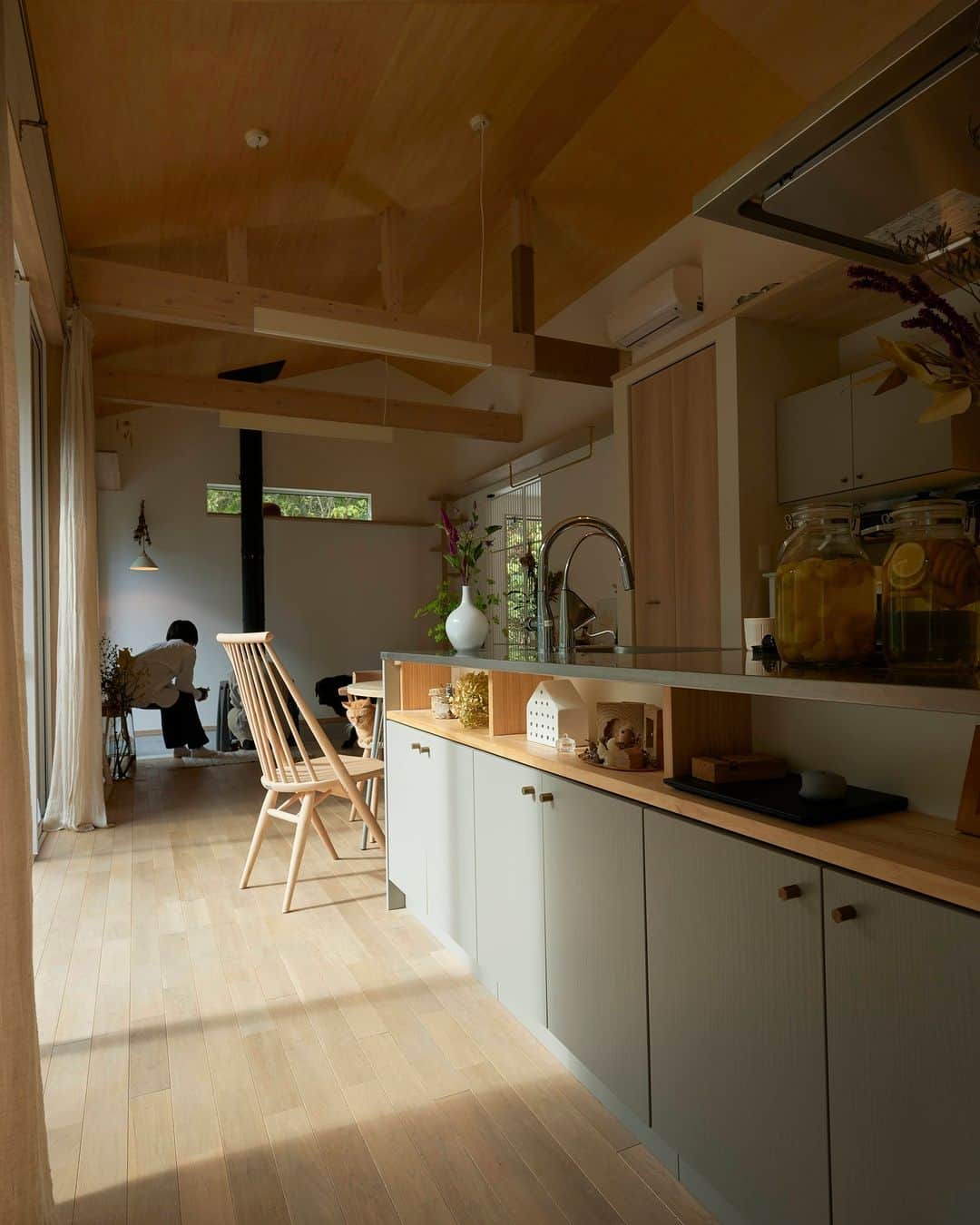 ムクリ［mukuri］さんのインスタグラム写真 - (ムクリ［mukuri］Instagram)「四季を感じるキッチンダイニング。家族との会話や、人との繋がりが生まれる場所〜素朴さの中に小さな贅沢を散りばめた２１坪の平屋（hy___home21さん）  yumiさんのおうちの キッチンダイニングの前には 家の中で一番大きな窓があります。  その窓は 四季を感じる暮らしがしたい思いを 叶えてくれました。  キッチンは 「２０年越しの片思いが実った感覚」で メーカーのものを採用。  食を大切にし、家族との会話が弾む 暮らしの源でもあります。  友人など来客がたくさん集まるのも 居心地がいい空間が広がり 包み込んでくれる空気が あるからなのでしょうね。  yumiさんの暮らし ぜひ参考にしてくださいね♩  @hy___home21 さん ありがとうございました！  （編集：kaori）  ▶コラムはプロフィールのURLよりご覧ください プロフィールはこちらから @mukuri_official ・  –––––––––––––––––– ムクリ公式アカウントでは くらしの中にある"好き"や"コダワリ"を毎日お届け。  インテリア、整理収納から家づくりなど 日常で参考になる情報から サラッと読める短編コラムまで ご紹介していますのでフォローしてぜひご覧ください。 ▶︎ @mukuri_official ・  「 #ムクリ 」のタグもいつも楽しく拝見しています☺️  オリジナルブランドは @daily_mukuri  くらしの中にあったらいいいな、 そんな商品を企画・制作、集めています。 ––––––––––––––––––  #平屋 #平屋の暮らし #犬と猫との暮らし#ウッドワンキッチン #スイージーニュートラルカラー #シナベニヤの天井 #薪ストーブのある暮らし #irondogno7 #土間のある暮らし #オーク無垢材 #パグのいる暮らし #茶トラ #工務店のつくる家 #勾配天井リビング #四季を楽しむ #くらしの編集#ムクリ」4月24日 21時05分 - mukuri_official