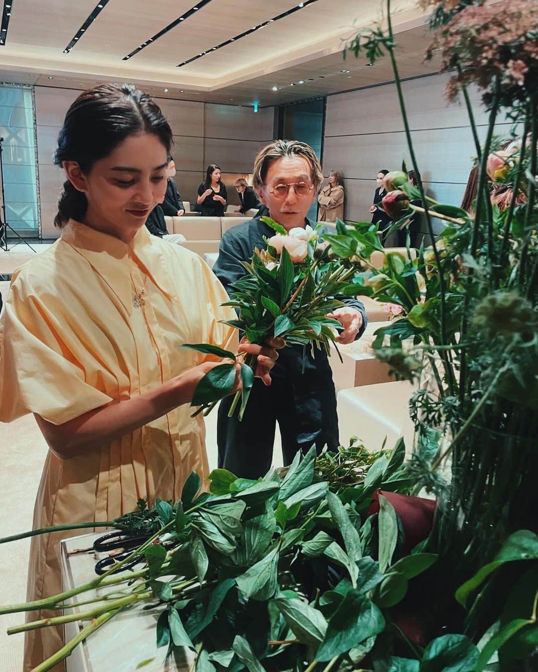 白澤貴子さんのインスタグラム写真 - (白澤貴子Instagram)「I had a great time in the flower-arrangement class by @flowernoritake   昨夕は大好きな則武さんがフラワーアレンジメントのスペシャルワークショップを開催されるとのことで、銀座のアルマーニタワーへ。  今回のイベントはARMANI beauty のフレグランスコレクション、「アルマーニ プリヴェ」によるもの。  今まで買ったお花は家の花瓶に感覚的に入れていただけだったから、ブーケ作りの基本、スパイラルというテクニックを学べてとても勉強になったけれど、とにかく難しかった笑。 同時に、則武さんのセンスがいかに素晴らしいかを改めて実感する良い機会にもなったな。  ちなみに今回のブーケのメインにもなった芍薬は、母の日に贈る花としてフランスでは定番だそう。 実は我が家も、息子からの母の日のプレゼントはここ数年ずっと芍薬。 そのコロンとした蕾から、この上なく華やかな咲き姿、そして崩れるような散り際まですべてが美しいことにすっかり魅了され、私もこうありたい、なんて毎年眺めながら物想いに耽るのが５月の私のお決まり。  アルマーニ プリヴェの一番人気、「ピヴォワンヌ スジョ」も芍薬をメインにしたフラワー系の香りでありながら甘ったるさのない引き締まり方で、爽やかさと芯を感じさせる凛とした香り。  そして、私が最もときめいた、新作の「サンタルダンシャ」と教会を想起させる「オニキス」もおすすめ。  紳士淑女の皆さま、今年の母の日にはフレグランスと芍薬のブーケのセット、なんていう小粋な贈り物 はいかが？  #Armanibeauty #ArmaniPrive #Fragrance #PR」4月25日 11時01分 - takakoshirasawa