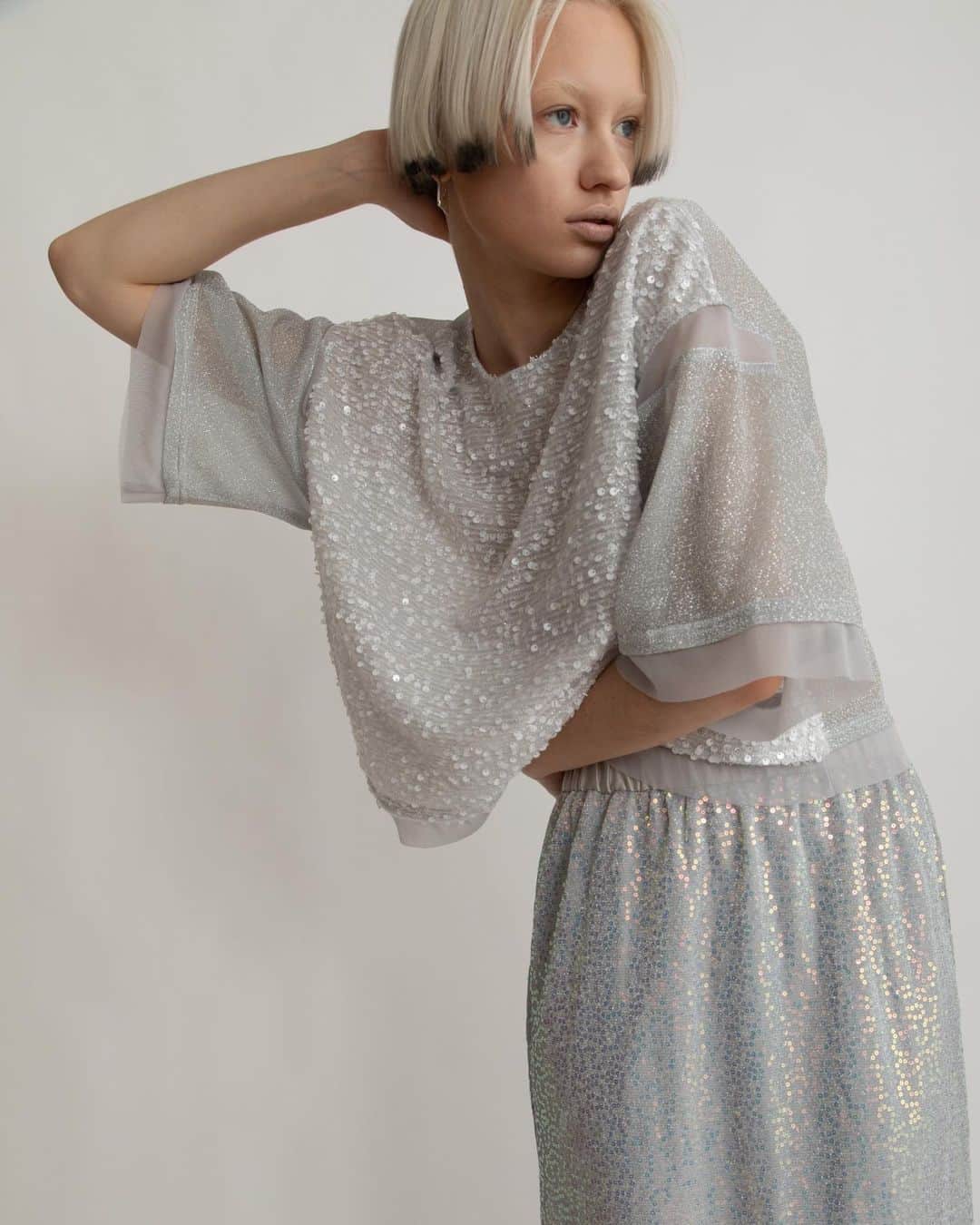 AULA AILAのインスタグラム：「【2023 HIGH SUMMER COLLECTION】  2WAY METALLIC T-SHIRT COLOR SILVER SIZE 0 ¥16,500  メタリックスパンコール生地と、ラメジャージー生地の前後どちらでも着用できる、2WAYのTシャツ。  肩にチュールスリット、袖口と裾もチュールで切り替えております。 オーバーサイズの長すぎない丈のTシャツは、タイトなボトムにもボリュームのあるボトムにも、バランスよく合わせやすいアイテム。  SPANGLE STRAIGHT SKIRT SET COLOR SILVER SIZE 0/1 ¥18,700  スパンコール生地のスカートと、ソフトオーガンジースカートがセットになったアイテム。 オーガンジースカートを上側にして着用すると、スパンコールスカートのキラキラがほんのり透けて見え、柔らかで上品なイメージに。 スパンコールスカートを上にすると、裾から透け感のあるオーガンジーが覗きレイヤードスタイルを楽しめます。 スパンコールスカートは伸縮性がありタイト過ぎないストレートラインなので、着心地良く、裏地付きなので単品でも着用可能。 オーガンジースカートはパンツに重ねたり、プラスワンアイテムとしてスタイリングに取り入れても◎   ✔️AULA AILA OFFICIAL WEB STOREにて HIGH SUMMER COLLECTIONアイテム展開中！」