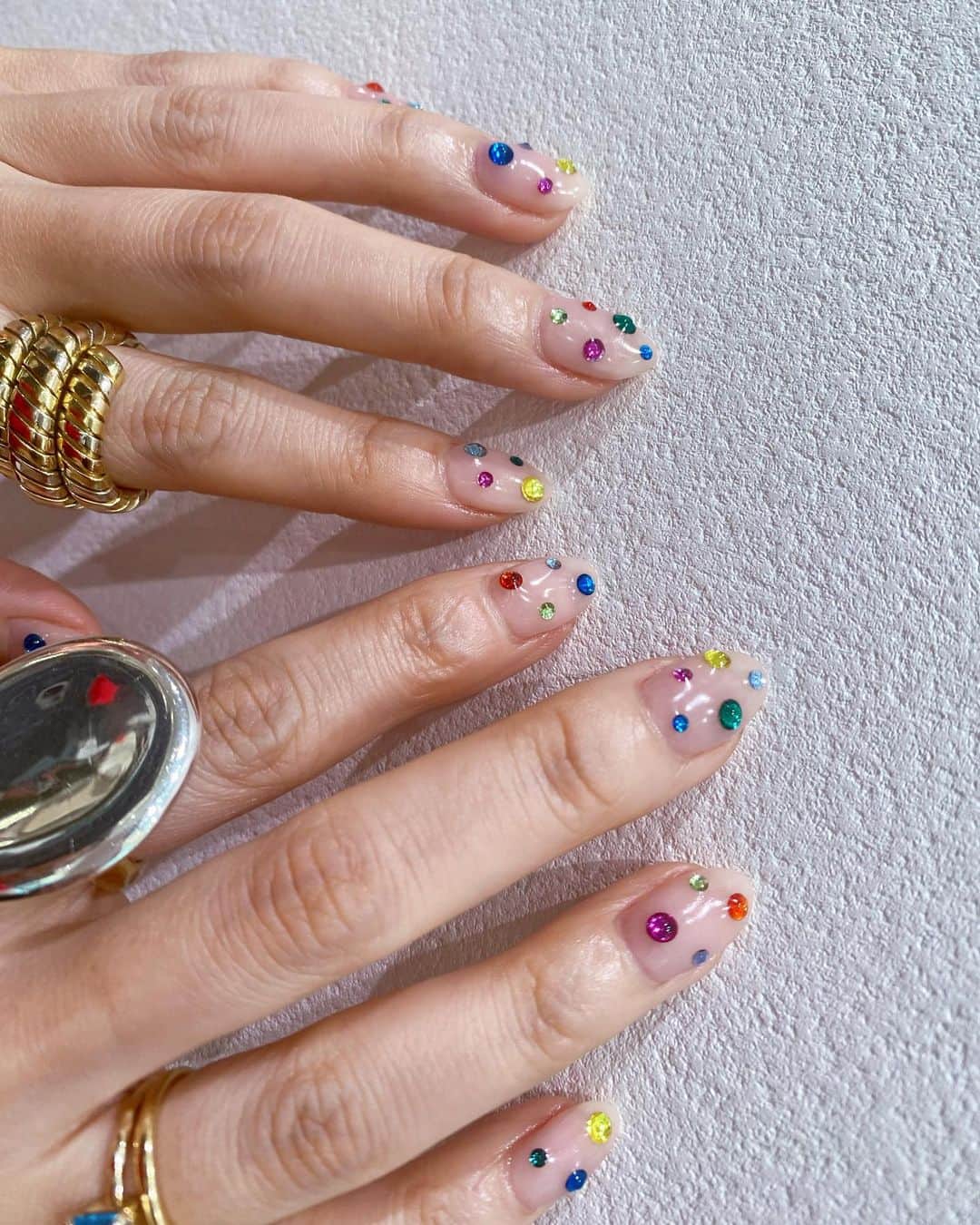 松本亜希のインスタグラム：「・ new nail💅 今回のネイルも最高に気に入っておる。 カラフル気分だったので、薄いベージュベースにいろんな色のストーンを💚💛💜💙  めっちゃ派手だけど、いろんな色が入ってるから服とも結構合うし、なにより褒めてもらえる♡ ちなみにフットネイルもベースの色は違うけど 同じカラーストーン仕様にした♬  いやー可愛いわ。 @corsokiri ちゃんいつも有難う❤️❤️  _________________________ #nail #ネイル #カラフルストーン #カラフルストーンネイル#カラフルネイル #ネイルアート#ネイルデザイン  #instanail #newnail」
