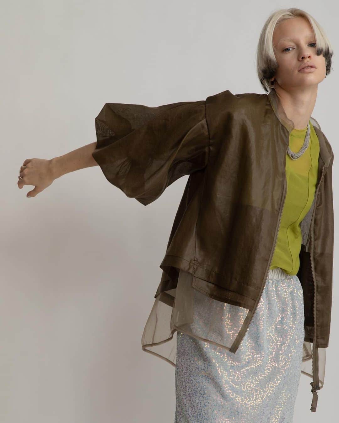 AULA AILAのインスタグラム：「【2023 HIGH SUMMER COLLECTION】  HALF SLEEVE LAYERED BLOUSON COLOR KHAKH SIZE 0 ¥25,300  薄手のレザーのような光沢感と本来のスパンボイルの透け感が相まって、新鮮な印象に。  タックでボリュームたっぷりな5分袖のブルゾン。 見頃は内側にチュールがレイヤードされているため、裾からチュールが覗き、シアー感が涼し気なデザイン。    SPANGLE STRAIGHT SKIRT SET COLOR SILVER SIZE 0/1 ¥18,700  スパンコール生地のスカートと、ソフトオーガンジースカートがセットになったアイテム。 オーガンジースカートを上側にして着用すると、スパンコールスカートのキラキラがほんのり透けて見え、柔らかで上品なイメージに。 スパンコールスカートを上にすると、裾から透け感のあるオーガンジーが覗きレイヤードスタイルを楽しめます。 スパンコールスカートは伸縮性がありタイト過ぎないストレートラインなので、着心地良く、裏地付きなので単品でも着用可能。 オーガンジースカートはパンツに重ねたり、プラスワンアイテムとしてスタイリングに取り入れても◎   ✔️AULA AILA OFFICIAL WEB STOREにて HIGH SUMMER COLLECTIONアイテム展開中！」
