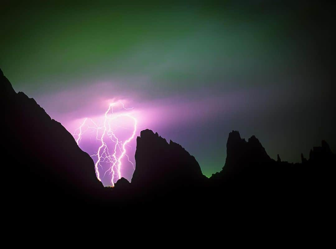 Keith Ladzinskiのインスタグラム：「Purple on Green / I remember shooting this photo in 2001 and hating the green hue at the time, which is effectively the city lights reflecting off the stormy skies. The sky was green because I had shot this on Fuji Velvia film, day light balanced film at 5600k, which interprets tungsten light is green. Today you’d just balance it out in-camera but with film, you had two choices: swap out the roll with tungsten film, or deal with the green. Today, looking back, I kinda like the look. What do you think? - - #Gardenofthegods #velvia #film #lightning」