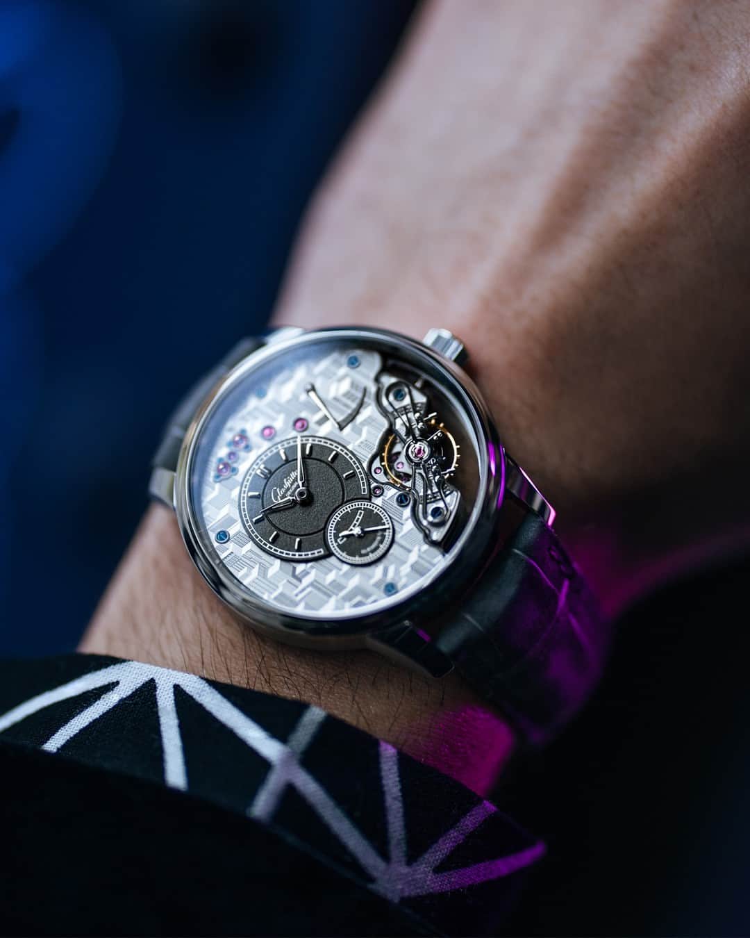 グラスヒュッテのインスタグラム：「The new PanoInverse Limited Edition opens up spectacular insights and views. Finely engraved skyscraper canyons on both sides of the movement invite you on a fascinating journey, and thanks to sapphire crystal and skeletonisation, the wearer becomes part of this elaborate scenery: your own wrist can be seen through the watch and provides the background for the city of your dreams. Proud to be the Original.  #GlashütteOriginal #GlashuetteOriginal #PanoInverse #Pano #LimitedEdition #ptbto #MadeInGermany #newrelease #novelty #GONovelties2023 #platinumwatch #UrbanLifestyle」
