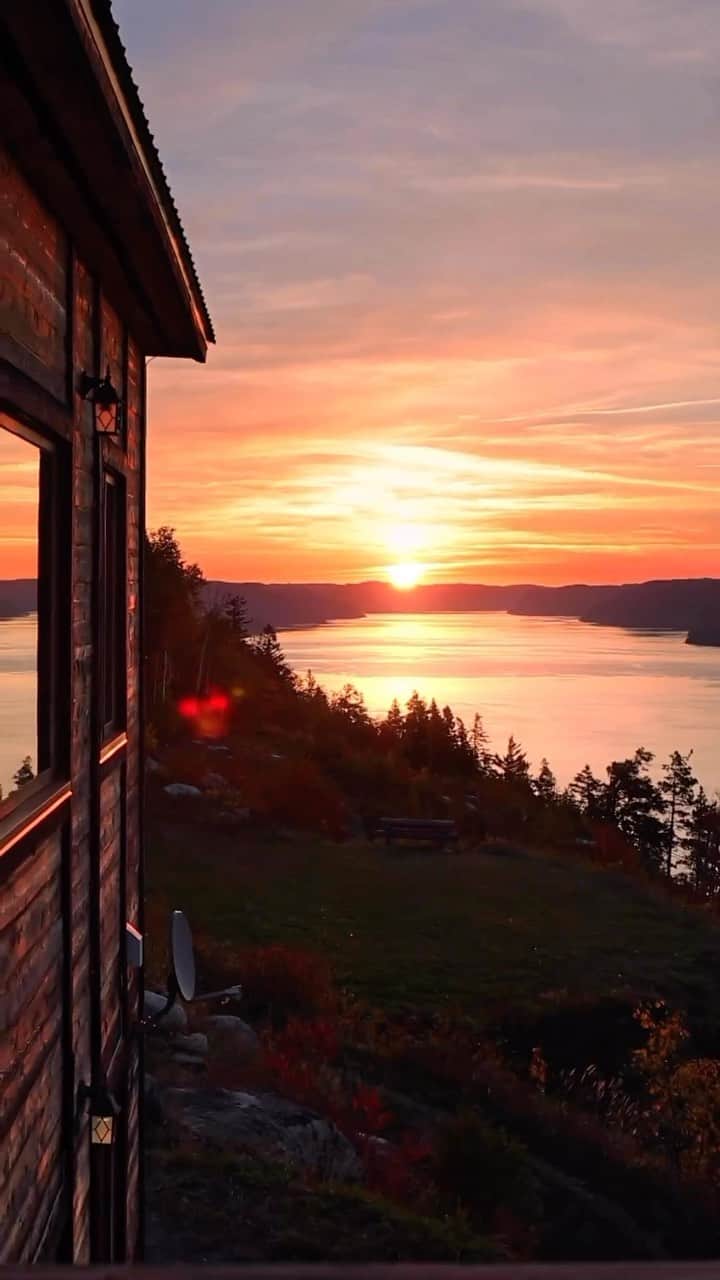 Explore Canadaのインスタグラム：「Tell us your favourite place to watch the sunrise in Canada 🌅 This viewpoint in Saguenay, Quebec is a great contender!   📷: @argenel 📍: @saguenaylacsaintjean, @tourismequebec  #SagLac #BonjourQuebec    [Video description: Walking along a wooden deck overlooking a large body of water, a bright orange sunrise makes its way above the hills in the distance, casting a golden glow on the landscape.]」