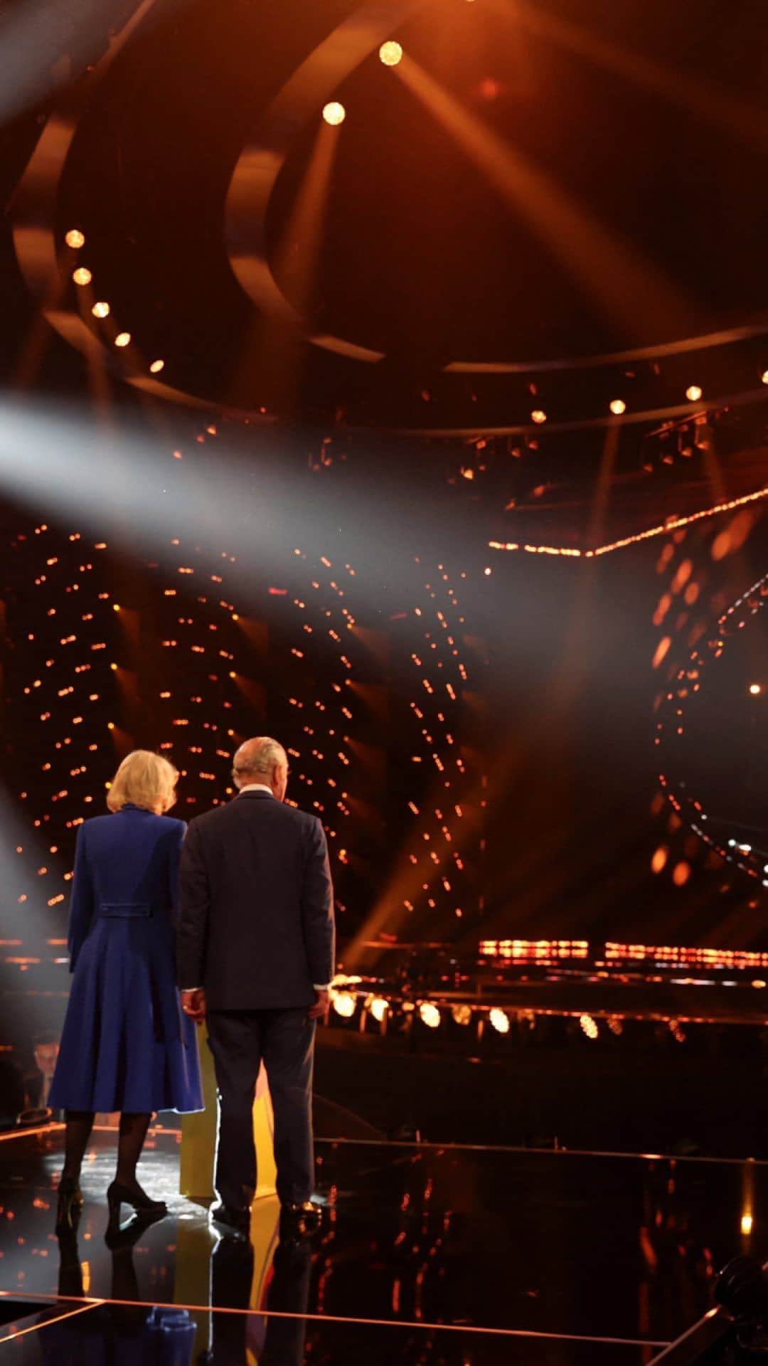ロイヤル・ファミリーのインスタグラム：「Ahead of Eurovision 2023, The King and The Queen Consort have visited Liverpool to see how preparations are coming along for the contest, which the UK is hosting, on behalf of Ukraine, for the first time in 25 years. 🇬🇧🇺🇦  Their Majesties met representatives from the BBC; staff and apprentices preparing the Arena; and some of this year’s hosts of Eurovision - Julia Sanina (@the_hardkiss), @realscottmills, @Rylan Clark and @hannah_waddingham.  The King and The Queen Consort also got a quick chance to wish UK entrant @maemuller the best of luck!  📚 Later, as Liverpool Central Library twins with Ukraine’s first public Library, the Regional Scientific Library in Odesa, Their Majesties popped in to hear about the two-week cultural festival that will run alongside Eurovision.  Eurolearn, a Eurovision-inspired education programme for primary and secondary pupils, recognises the cultural partnership of the UK and Ukraine to celebrate the contest.  It was wonderful to meet so many enthusiastic young people engaging with the library’s activities - and a special thank you to @olenazelenska_official for joining us virtually! 🙏」