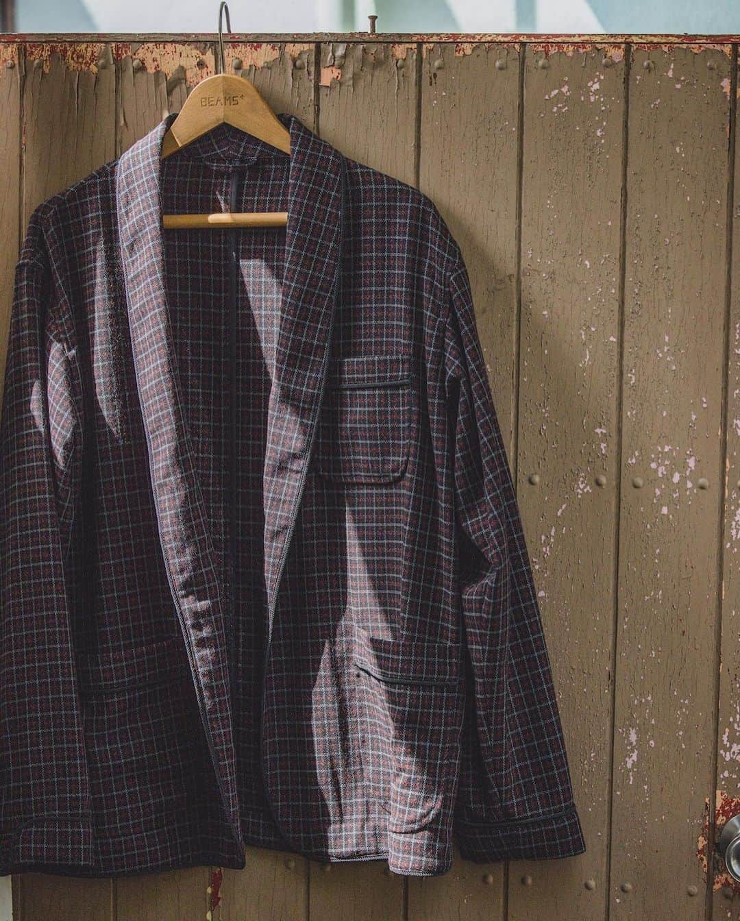 のインスタグラム：「… “A smoking jacket” It sounds a bit difficult to approach, but it is actually a kind of elegant jacket worn on formal occasions.  It’s also called a tuxedo or dinner jacket. Gentlemen who enjoyed smoking in a cozy place would surely have worn it in a relaxing way. The pants paired with this jacket are inspired from the design of military pajama pants. The pocket details have been updated to make them easy to wear as a casual wear. A Panama weave material made from wool adds a refreshing look and its rough surface allows for excellent breathability. A high-twisted triplet yarn made of 2/60 wool yarns also makes it luxurious and dry touch.  Enjoy a classy style with this set-up that combines relaxation and elegance.  スモーキングジャケットって、名前はちょっと近寄り難いけど・・・、フォーマルな場で着用される、エレガントなジャケットの一種。スモーキングジャケットの別名はタキシードや、ディナージャケットって呼ばれることも。 くつろいだ場所で煙草を嗜む紳士は、きっとリラックススタイルとして着用していたはずである。 合わせたパンツは、ミリタリーのパジャマパンツがデザインモチーフ。タウンユースにも着用しやすいようにと、ポケットディテールをアップデート。  見るからに涼しげな素材使いは、ウールを原料にしたパナマ織。粗めな素材の表面、通気性も抜群。ドライなタッチは2/60のウール糸を三子糸に強撚したなんとも、贅沢なパナマ素材。リラックス&エレガンスを兼ね備えたセットアップで、上品なスタイルを楽しんでみては。 . Jacket_1B Smoking Jacket Wool Panama Shirt_Ikat Madras Band Collar Pullover Shirt Pants_MIL Easy Pants Wool Panama . @beams_plus @beams_plus_harajuku @beams_plus_yurakucho #beamsplus」