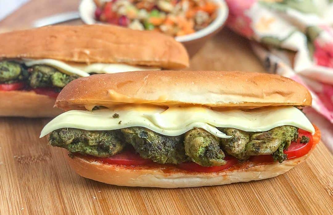 のインスタグラム：「The grilled Basil Pesto Chicken Sub Sandwich Recipe is a Sandwich recipe where succulent pieces of chicken are cooked in a marinade of freshly ground basil pesto, and packed in a sub sandwich along with some cheese. Have this with your favorite drink and tell me how you enjoyed :)  Ingredients 2 Hot Dog Bread 2 Cheese Slices 2 tablespoons Classic Mayonnaise 2 tablespoons Sweet and Spicy Red Chilli Sauce 1 Tomato, thinly sliced For the Grilled Basil Pesto Chicken 1 Chicken breasts 1 tablespoon Fresh cream 1 teaspoon Lemon juice 2 tablespoons Garlic Butter For Fresh Basil Pesto 125 grams Basil leaves 2 tablespoons Walnuts, toasted 4 cloves Garlic, finely chopped Salt, to taste 1 tablespoon Extra Virgin Olive Oil 1/2 tablespoon Whole Black Peppercorns 1/4 cup Parmesan cheese  👉Let's make the fresh basil pesto and keep it ready. We will first have to grind all the ingredients together. 👉In a food processor, combine basil leaves, walnuts, garlic, salt, crushed black peppercorns and cheese. Blend until the mixture is a coarse paste 👉With the processor running, slowly pour the olive oil into the bowl through the feed tube and process until the pesto is thoroughly pureed. 👉Next add the Parmesan and puree for a minute. Transfer to a bowl and set aside. 👉In a mixing bowl, marinade the chicken breast along with pesto, cream, and lemon juice. Let it sit for about an hour. 👉Heat a grill pan/skillet on medium flame, put some garlic butter, and place the chicken breast on it allow to cook on both sides for about 8-10 minutes on each side. 👉Set aside. Cut them into slices or small chunks. 👉Slice the hot dog bread horizontally, lightly apply butter and toast on a griddle on low flame, and turn off the heat. 👉Place the two halves of the hot dog bread, on a countertop, apply red chili sauce on the base, arrange tomato slices, and the pesto chicken pieces, and place the cheese slices over it. 👉Finally, spread mayonnaise on the inside of the top half of the hot dog bread and close the sub sandwich.  Find 1000+ such recipes on our app "Archana's Kitchen" or website www.archanaskitchen.com . . . . . #recipes #snacks #sandwich #pesto #pestosauce #chickensandwich」