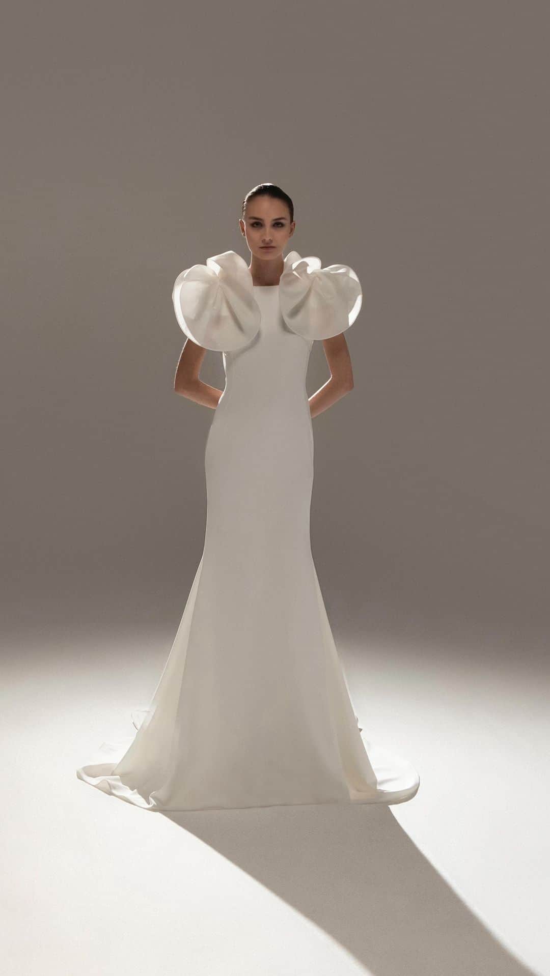 ステファンローランのインスタグラム：「LE COURAGE D’AIMER  Long gown in white crepe with an open back embellished with detachable orchids sculpted in white gazar.   EPURE  A capsule line of 10 bridal gowns available in the Parisian showroom of Stéphane Rolland and partner stores all around the world.  #StephaneRolland #Bridal #WeddingInspiration」