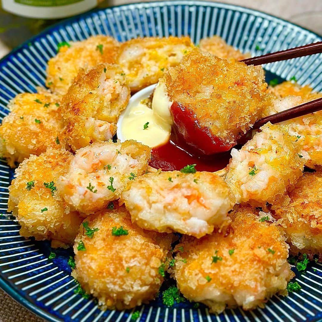 のインスタグラム：「今日は海老好きの方にはぜひお試しいただきたい、めちゃウマなチーズ入り海老カツをご紹介します🤗✨ はんぺんを使うことでふわふわ食感に、海老はきざみ方を変えてアクセントをつけるのも大切なポイントです😋💕   卵は使わずにパン粉をまとわせて、少なめの油で揚げ焼きにするので作り方もめちゃくちゃお手軽です🙌🏻 それでは作り方をご紹介します😌✨      ふわふわプリプリ♬ はんぺん入りチーズ海老カツ♬  【材料】２人分 ◎むき海老・・・１５０g ◎はんぺん・・・１枚(１００g) ◎チーズ(ピザ用)・・・４０g ◎マヨネーズ・・・大さじ１ ◎片栗粉・・・大さじ１ ◎塩・・・小さじ１／３ ◎こしょう・・・少々 ◎パン粉・・・適量 (お好みで) ◎ケチャップ・・・適量 ◎マスタード・・・適量 ◎パセリ・・・適宜       【作り方】 １．むき海老の２／３を粘りが出るまで細かく刻み、残りの１／３は食感を残すため大きめに切ります。   ２．はんぺんを袋ごと握りつぶすように細かく千切ります。   ３．ボウルに海老、はんぺん、チーズ、マヨネーズ、片栗粉、塩こしょうを加えてよく混ぜ合わせます。   ４．食べやすい大きさに丸めます。   ５．薄くパン粉をひいたバットに並べ、全体にパン粉を纏わせます。   ６．フライパンに5mm程度の深さの油を入れ中火で熱し、油が温まったら海老カツを投入して、中火〜弱火で焦げないように揚げ焼きにしていきます。 狐色に焼け上がったらひっくり返しましょう。   ７．最後に強火で両面サクッと焼き上げたら、油を切りましょう。   ８．お好みでケチャップ、粒マスタードなどをつけていただきましょう。    サクッとした衣に、ぷりぷりの海老とはんぺんのふわふわ食感、さらにとろーりチーズが絡んで最高です😋💕 お子さまのおかずから大人の方のおつまみにもなる、みんな大喜びの１品ですよ✨ 多めに作って翌日のお弁当に入れると喜ばれること間違いなしです🙆‍♂️ 海老好きの方はぜひお試しくださいね😌✨   　 より詳しいレシピはお手数ですがブログを見てください🤗✨ プロフィール欄のURL(@shinya6727 )、もしくはストーリーズのスワイプから飛べます😌✨  【お知らせ】 私の２冊目のレシピ本、「しにゃのやみつき！つまみ飯」重版されております🙌🏻 いつも応援してくださる皆さまのおかげです😂🙏 なるべくシンプルな食材や調味料、どこにでもある調理器具を使って作れるやみつきレシピをまとめた１冊になっております📚 お料理が好きな方も苦手な方も楽しんでいただける内容になっています😊  いつも通りの鶏むね肉やもやし、厚揚げといった、リーズナブルでヘルシーな食材を使った大満足レシピを多数掲載してます🙌🏻 とにかく幅広い方のお役に立てるレシピ本となっていますので、多くの方に手に取っていただけたら嬉しく思います😌🙏 お買い求めはAmazon、楽天などのネット通販か、全国の書店で📚 どうぞよろしくお願いします😊 ・ ・ ・ #レシピ #recipe #簡単レシピ #料理 #おうちごはん #おうち飲み #チーズ #海老 #shrimp #カツ #おつまみ #おかず #ビール #cheese #はんぺん」