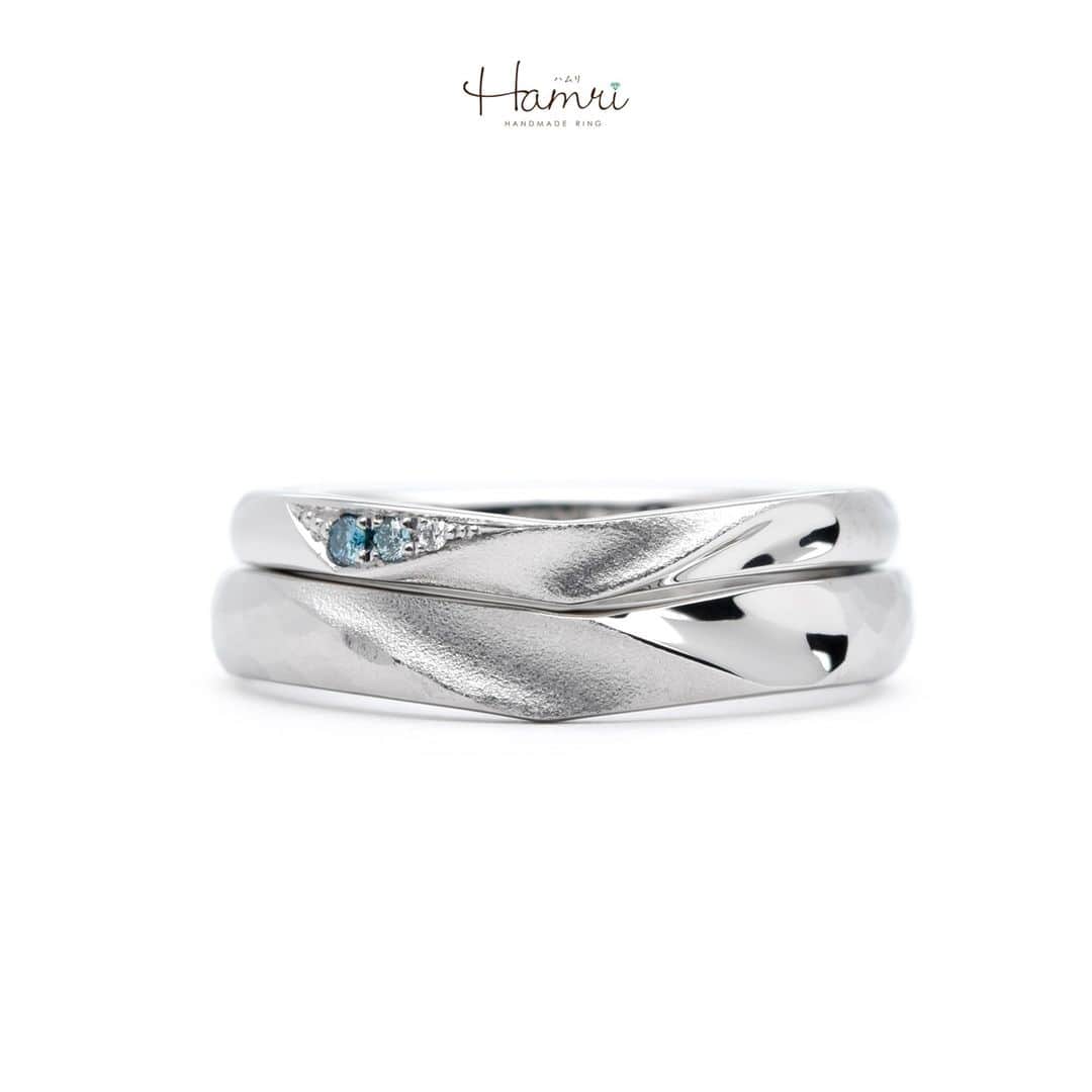 結婚指輪・婚約指輪『Hamri(ハムリ)』さんのインスタグラム写真 - (結婚指輪・婚約指輪『Hamri(ハムリ)』Instagram)「【V字のハートデザインをご紹介です】  おふたりの好きな形や加工、全てが加わった特別なデザインとなっております！  大枠の形はV字となっており、2本が重なるようになっております。  ご新郎様は全体に細かいハンマー加工を施しており  おふたりともが真ん中部分の凹みとマット加工を加えることで、少しひねったような形を表現しております。     重ねたらハートになる形をとても気に入ってくださっており、V字なので斜め部分にハートを加えたのがこだわりです！  宝石に関しては、ご新婦様は左端にグラデーションでブルーのダイヤモンドを留めており  内側にはおそろいで誕生石のオレンジサファイアを留めました。  全てがオリジナルの素敵なデザインです！  ご結婚おめでとうございます！  💓ふたりらしい指輪と想い出を💓 @hamri_omotesando ==========================  ♦︎♢作成中の写真や動画を撮影、全データプレゼント♢♦︎  DMやLINEでのご相談お待ちしております♥ ⇒@hamri_omotesando  ❁・❁・❁・❁・❁・❁・❁・❁・❁・❁・❁  ＊セットリング5%OFF＊  @hamri_omotesando  Hamri「ハムリ」  〒150-0001 東京都渋谷区神宮前5-11-11 2F  tel 0120-121-175 hp https://hamri.jp/  open 11:00〜19:00 close 火/水　祝日営業  ❁・❁・❁・❁・❁・❁・❁・❁・❁・❁・❁  #手作り結婚指輪 #手作り婚約指輪 #結婚指輪#マリッジリング #エンゲージリング #プレ花嫁 #Hamri #Hamri表参道 #オーダーメイドリング #鋳造 #ブライダルリング #ペアリング #鎚目リング #プラチナリング #ピンクゴールド #シャンパンゴールド #ゴールドリング #コンビネーションリング #2023wedding #2023春婚 #2023夏婚 #プレ花嫁準備 #プレ花嫁と繋がりたい #結婚指輪探し #結婚指輪選び #結婚準備  《Hamri検索タグ》  #Hamriデザイン #Hamri指輪作り #Hamri花嫁」4月28日 14時02分 - hamri_omotesando