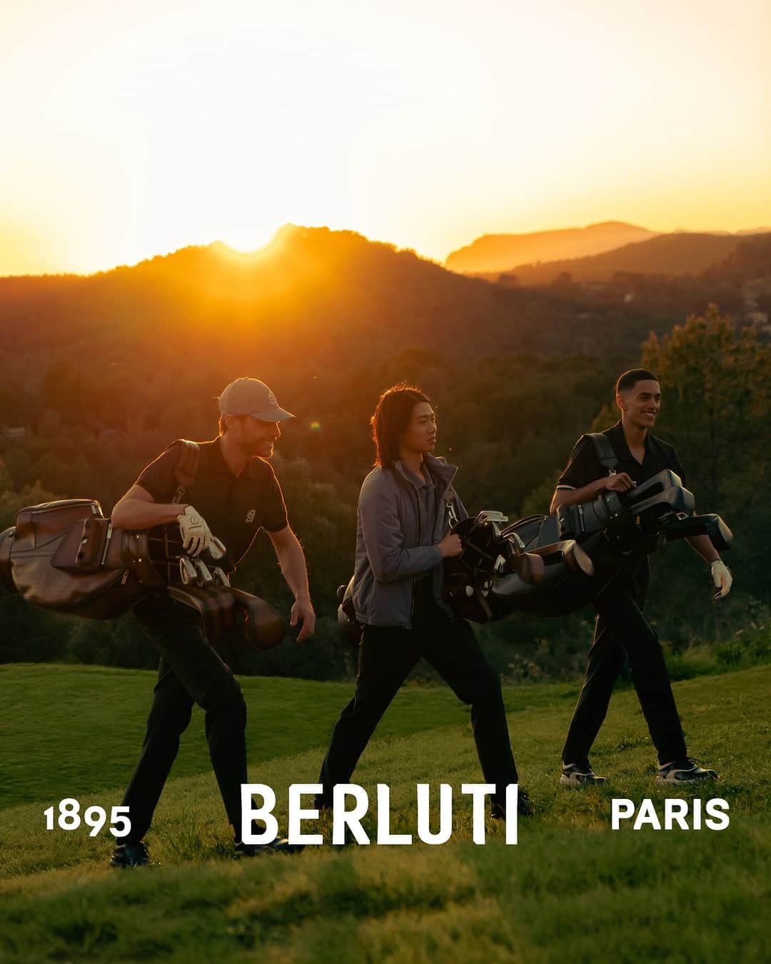 ベルルッティのインスタグラム：「- GOLF BY #BERLUTI -  As sunset casts a warm glow over a scenic view, players finish their round to get into an après-golf mood. The multifunctional Venezia leather cart bag and a soft, patinated lamb leather blouson embroidered with an original B logo are their inseparable companions as they walk away from the course.   Now available online and in-store and golf bag available on special order.   Photography by @nelson_rosier   #TEEOFFWITHBERLUTI」