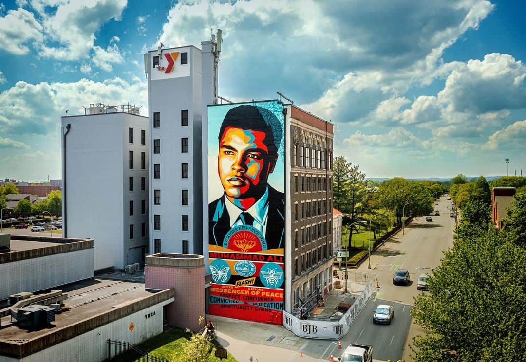 Shepard Faireyのインスタグラム：「The crew and I just returned from Louisville, KY where we painted a 7 story mural of one of my heroes and a son of Louisville, @muhammadali. Ali was an incredible athlete who was dazzling in the ring, a glorious showman athletically and verbally, and resilient in the face of defeat, earning the heavyweight title 3 times. However, in this mural, based on an incredible photo by Howard Bingham provided by his son Dustin (@dusbing), I wanted to emphasize Ali’s role as an outspoken citizen and activist. Ali was a civil rights activist, a conscientious objector to the the Vietnam war, a philanthropist, and a U.N. Messenger of Peace. I admire that Ali stood up for what he believed even when he potentially faced jail and the end of his boxing career. The Chestnut St. YMCA (@chestnutstreetymca) where we painted the mural is blocks from Ali’s childhood school and a place he frequented in his youth. I’m very grateful to the YMCA for providing an incredible wall with an authentic connection to Ali’s life. A project of this magnitude can’t come to fruition without a lot of people to collaborating generously. My friend of 25 years, Eddie Donaldson of @guerillaone led the charge on bringing this project together, as well as the Outside Influence art show to benefit Artists for Trauma. Eddie pulled together an amazing coalition of supporters including the Mayor, Danny Wimmer Presents, Kroger, and many others (Instagram tags below). A big thanks to my crew of Dan Flores, Rob Zagula, and Jon Furlong, who also shot the great photos. Also, thank you to the city of Louisville for the warm welcome into the community and for giving me the privilege of adding to the cityscape. I met a ton of great local artists at the Outside Influence art show. Thank you all for the kind support! –Shepard  @krogerco @phocus @mayorgregfischer @louisvilleforward @dannywimmerpresents @dannywimmer @fifteentwelve_portland @adidas @stanceofficial @solodomellc @indivisible_arts @spinellispizza_ @rangemp @kentuckypeerless @esoteric_collection @mayorcraiggreenberg @artistsfortrauma  @loumetropublicart」
