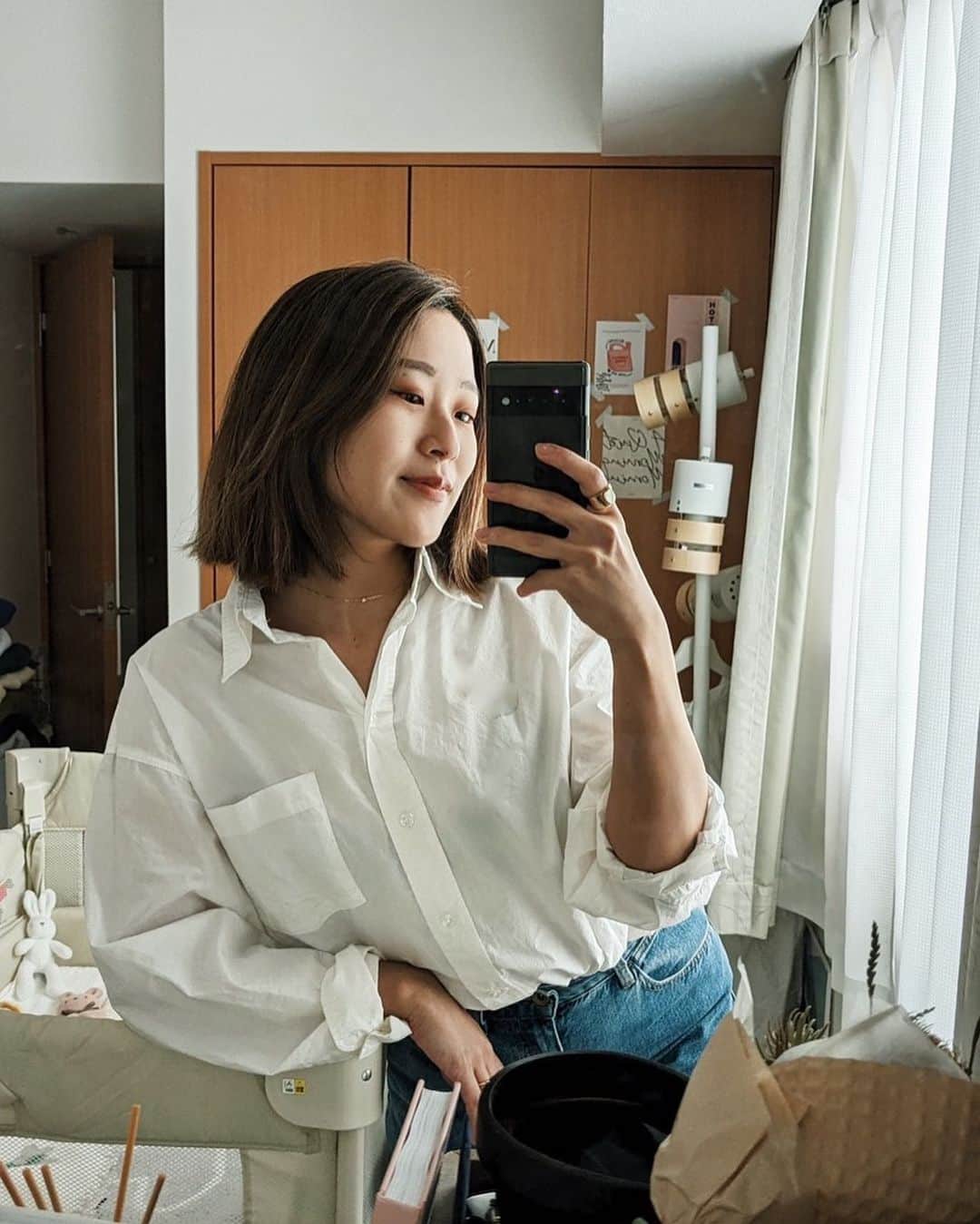 上野智子のインスタグラム：「週5でデニム♡ カーブジーンズの履きやすさにやられ、スタメンデニムになっています。 写り込んでいるベビーベッドは姪っ子のお下がりのアップリカ。重宝！とにかくよく寝てくれる&運びやすくてよいです。ちなみに今は大人のベッドの横にベビーベッドを置いて同じ部屋に寝ています。もう少ししたら子供部屋に移動かな:) おしゃれな木製も憧れたけどね、使いやすさと寝やすさ重視ですね👶   #outfit #mirrorselfie #デニムコーデ #カーブジーンズ #ベビーベッド #女の子ママ #ベッドルーム #白シャツコーデ #デニムコーデ」