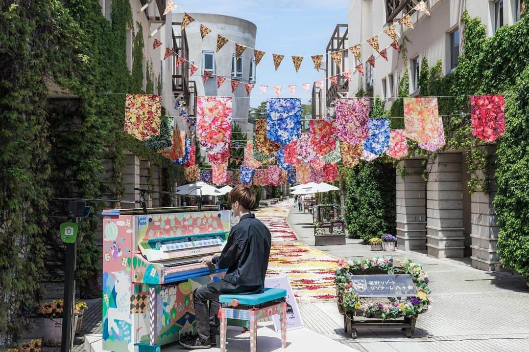 星野リゾート リゾナーレ八ヶ岳 【公式】のインスタグラム：「「旅するLovePiano」6カ所目のリゾナーレ八ヶ岳では、設置初日の4月28日にオープニングイベントを実施しました🌷 イベントではスペシャルゲストとしてピアニストよみぃ氏が登場し、開催中のイベント「回廊の花咲くリゾナーレ」にちなみ、「花」をテーマにした楽曲など全5曲を披露しました💐 花の装飾で彩り豊かなピーマン通りで5月28日までどなたでも自由に弾いて楽しめます🎹  #星野リゾート #リゾナーレ八ヶ岳 #星野リゾートリゾナーレ八ヶ岳 #旅は魔法 #八ヶ岳#yatsugatake#山梨＃yamanashi#山梨旅行#山梨観光 #HoshinoResorts #risonareyatsugatake#ワインリゾート#ワイン#山岳リゾート#旅するLovepiano」