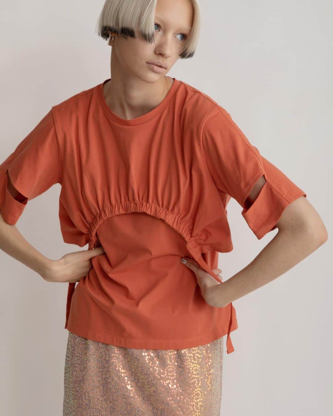 AULA AILAのインスタグラム：「【2023 HIGH SUMMER COLLECTION】  DRAWSTRING T-SHIRT COLOR ORANGE SIZE 0 ¥26,400  ルーズすぎずタイト過ぎないほど良いサイズ感で、すっきりと着られるTシャツ。 ショート丈Tシャツをレイヤードしているかのようなディテールが特徴。  SPANGLE STRAIGHT SKIRT SET COLOR ORANGE SIZE 0/1 ¥18,700  スパンコール生地のスカートと、ソフトオーガンジースカートがセットになったアイテム。 オーガンジースカートを上側にして着用すると、スパンコールスカートのキラキラがほんのり透けて見え、柔らかで上品なイメージに。 スパンコールスカートを上にすると、裾から透け感のあるオーガンジーが覗きレイヤードスタイルを楽しめます。 スパンコールスカートは伸縮性がありタイト過ぎないストレートラインなので、着心地良く、裏地付きなので単品でも着用可能。 オーガンジースカートはパンツに重ねたり、プラスワンアイテムとしてスタイリングに取り入れても◎  ✔️AULA AILA OFFICIAL WEB STOREにて HIGH SUMMER COLLECTIONアイテム展開中！」
