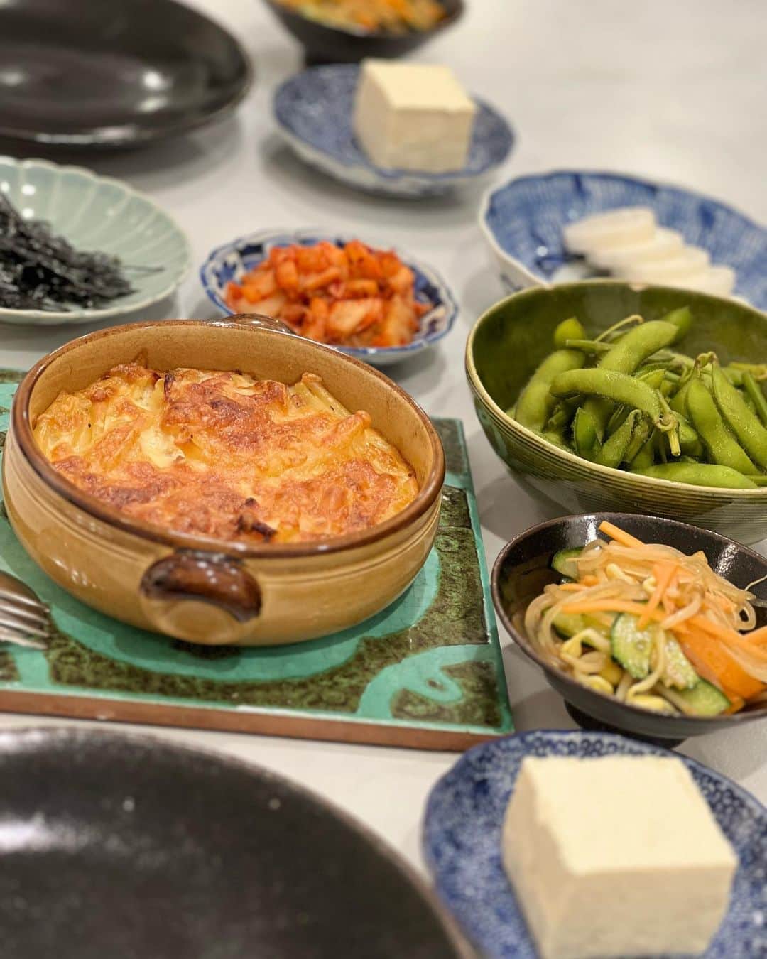 八木沼純子のインスタグラム：「休日ご飯。  ふるさと納税で頼んだメンチカツとコロッケ。 昨日の残りマロニーを中華風サラダっぽく。 カットした豆腐。 豆腐と一緒にキムチと海苔。 茹でた枝豆。 山芋切りました。 一人前マカロニグラタン。今日イチ豪華。 でも茶色い。 ・ ・ ・ #茶色いおかず  #画像が茶色っぽい😰 #マロニーサラダ  #枝豆  #休日ごはん  #おうち居酒屋  #焼酎かワインか #家人揚げ物担当 #富士ホーロー  #富士ホーローがきてから揚げ物多くなりました #ふるさと納税」