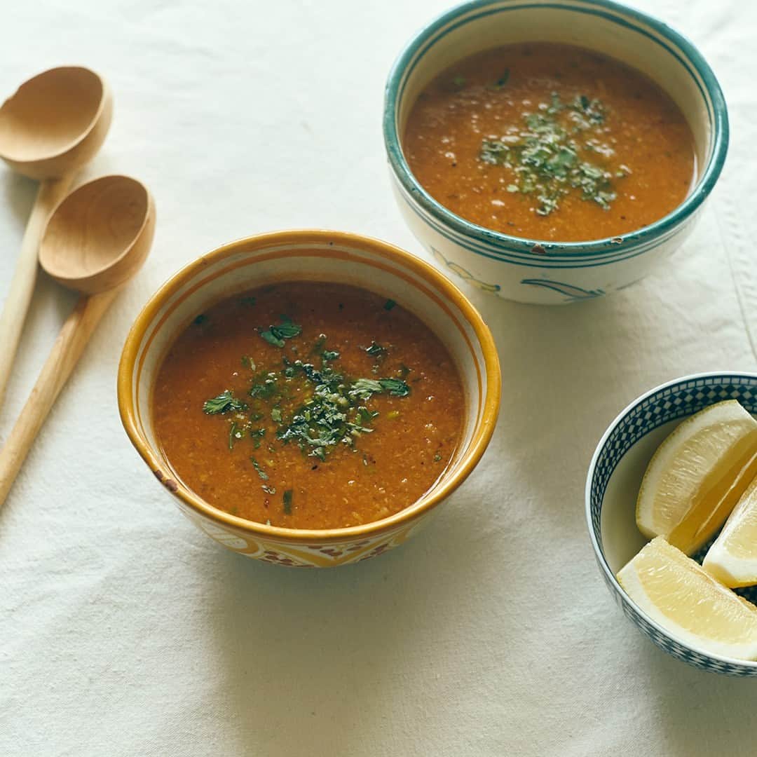 北欧、暮らしの道具店さんのインスタグラム写真 - (北欧、暮らしの道具店Instagram)「【異国の、お助けスープ】身体を芯からリセット。モロッコの、スパイシーな豆スープ . - - - - - - - - - - - -  世界の食材や料理を見てきた料理家 口尾麻美（くちお あさみ）さんに 教えていただくのは、 異国のキッチンでうまれた、 自分を元気にしてくれるスープ。  今回は、モロッコのキッチンから。 スパイシーな豆のスープ、 ハリラ「الحريرة（Harira）」です。 身体を芯から温めてくれる チャージレシピですよ。  - - - - - - - - - - - - - - - - - ホットで、スパイシー。 モロッコうまれの「豆スープ」 - - - - - - - - - - - - - - - - -  【材料（3~4人分）】 レンズ豆(乾燥したもの)…100g�ヒヨコ豆(茹でたもの。水煮缶がおすすめ)…100g�玉ねぎ…1/2個�セロリ…1/2本�トマト…2個�水…1~1.2L �A�・ジンジャーパウダー…小さじ2�・塩…小さじ1~2�・ブラックペッパー…小さじ1�・コリアンダーリーフ（パクチーでも可）…大さじ2�・イタリアンパセリ…大さじ2  トマトペースト（なくても可）…大さじ1�オリーブオイル…大さじ2~3�細めのパスタ…30g�レモンのくし切り…3~4個  【下準備】�・玉ねぎ、セロリはみじん切りにしておく。�・コリアンダーリーフ、 イタリアンパセリは 飾り用に少し残しておく。  【作り方】 ❶ 鍋にオリーブオイルを入れ、 玉ねぎとセロリを炒める。 しんなりとしたらAを入れて、さらに炒める。  ❷ トマト、水、レンズ豆も入れ、 沸騰したら弱火で20分ほど煮て、 トマトの酸味を飛ばす。 レンズ豆が煮崩れる程度にやわらかくなってきます。  ❸トマトペースト、ひよこ豆も入れて、 さらに10分煮る。  ❹ハンドミキサーでなめらかにする。  ❺短く折ったパスタを入れ、 パスタがやわらかくなるまで煮たら、 塩・ブラックペッパー(分量外)で 味を整えて、できあがり。  残しておいたコリアンダーリーフ、 イタリアンパセリをちらし、 レモンをしぼっていただきましょう。  - - - - - - - - - - - - - - - - - - - - - - -  口尾さん：�「今回はシンプルに豆だけで作ったハリラ。 ここに牛肉や羊肉を入れても美味しく出来上がります。 細かくしたパスタが、いい塩梅に スープにとろみをつけてくれて。 次の日になると豆がスープを吸って もったりとしてくるので、そのときは 水と塩を足して調節してみてくださいね。  ブレンダーがない場合は、コトコトとじっくり 豆を煮ているだけでも自然と煮崩れてくるので、 その食感を楽しんでも美味しく召し上がれますよ」  #food#foodstagram#レシピ#豆スープ#ハリラ#Harira#スープ#モロッコ#朝ごはん#ランチ#昼ごはん#料理#口尾麻美さん#暮らしを楽しむ#日々の暮らし#北欧#暮らし#北欧暮らしの道具店」5月2日 17時02分 - hokuoh_kurashi