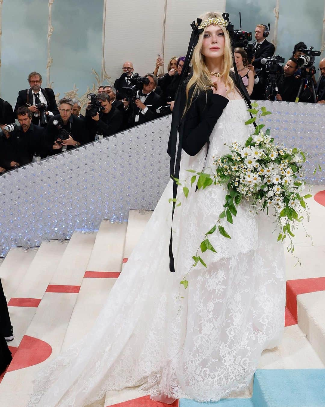 ヴィヴィアンウエストウッドさんのインスタグラム写真 - (ヴィヴィアンウエストウッドInstagram)「Elle Fanning wore a bespoke corseted dress in ivory Chantilly lace with a tailored, cropped black crepe jacket to the 2023 #MetGala in New York. @Ellefanning’s floral headpiece, crafted by @stephenjonesmillinery, featured fresh daisies on a black sinamay band with flowing black grosgrain ribbons.   Photography by Dimitrios Kambouris and Taylor Hill    Styling by @samanthamcmillen_stylist」5月2日 21時55分 - viviennewestwood