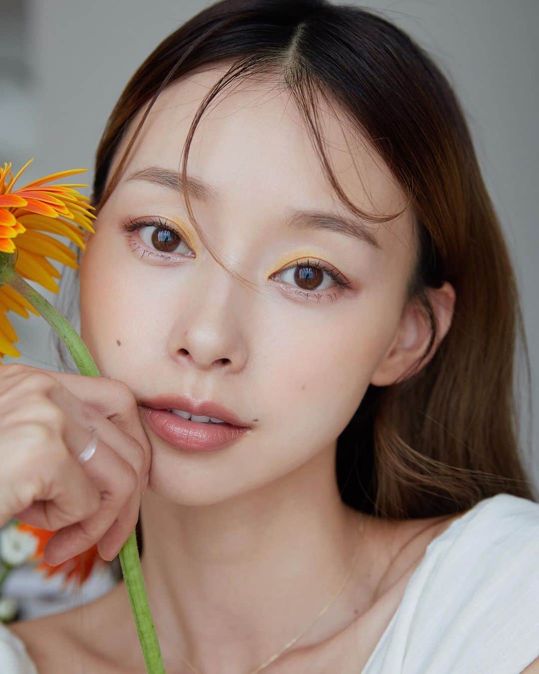 吳斐莉のインスタグラム：「走出化粧舒適圈～好驚艷🥹   以前看到棕色以外的眼影 心都會驚一下 想說真的只有超模們才能駕馭 那些藍藍綠綠黃黃真的欣賞就好😯  但是 SUQQU 真的太太太厲害  可以把任何顏色畫在亞洲人眼上是合理的  我原本覺得完蛋了  接了一個讓自己壓力好大的案子  別說畫出來好不好看  連怎麼畫都不知道😂 不習慣的用色萬一挑戰不成功會不會完蛋  但沒想到我畫完瞬間變日雜😍  這次的特調色彩  在配色中把透明與陰影感加入 化好的眼粧就像是維他命氣泡飲的光透清涼感 🍹  跟我一起用SUQQU第一波限量夏季彩粧系列 輕鬆打造出大人系專屬維他命色彩😚  🌻🌻🌻🌻🌻🌻🌻🌻🌻🌻🌻🌻🌻🌻🌻🌻 首圖是用-向日葵的花瓣-暖色調眼彩盤  晶采盈緻眼彩盤 123 照日葵 – SHOUJITSUKI  低明亮度的黃金色調+紫色組合  然後再搭配畫龍點睛的兩色 一個打造出透明感  一個粉色我上在下眼瞼  讓整個粧融合了起來  就像一杯夏日清涼的果汁汽水  可口的讓人想多看 2 眼😍  腮紅搭配晶采淨妍頰彩 -138 日向葵 – HYUUGAAOI  唇用晶采柔艷唇膏- 116 花橙 – HANADAIDAI 橘棕色調 整體的色彩平衡的剛剛好  又別緻又有巧思 怎麼可以這麼美🥹   🌿🌿🌿🌿🌿🌿🌿🌿🌿🌿🌿🌿🌿🌿🌿  另一個粧容是-向日葵葉子-冷色調眼彩盤  晶采盈緻眼彩盤124 日輪葉 – NICHIRINHA  腮紅搭配晶采淨妍頰彩 -139 果報 – KAFUU  唇用晶采柔艷唇膏 - 117 夏霞 – NATSUGASUMI   看起來無害又充滿仙氣的嫩綠粧容 真的就像拇指姑娘一樣 是從花裡長出來的女孩😍 而且不太需要什麼厲害技巧 只要底粧乾淨，好好暈染  整體就會很美 ～  這次把粧容重點放在眼睛 腮紅跟唇用的都是偏裸色系的 成果好喜歡❤️  向日葵檸檬氣泡水 V.S 春日嫩葉微酸汽水 DOUZO🙌🏿   @suqqutaiwan   #SUQQU #夏季彩粧 #2023PreSummer #向日葵妝容 #大人系維他命色調」