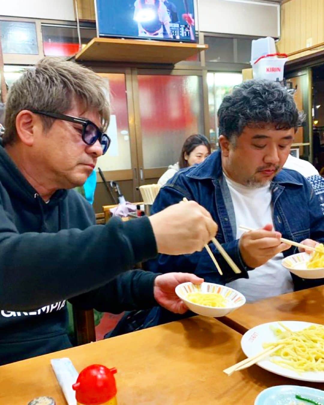 乾雅人のインスタグラム：「野毛ツアー@横浜 放送作家3人が野毛飲みやる日に「来い」と言われて…横浜中華街にオープンしたサウナに行くついでならええかと参入。 引率はグルメ界のGクラスこと塩沢航先生。 まずは写真🆖の通称「福田フライ」からスタート。ビールで乾杯！ここんちのフライ串は辛いニンニクたれでそのあと何を食べても繊細な味付けは不明になるが「よーし始まった」感がMAXに。 歩いて台湾料理「第一亭」の行列に並ぶ。パタン(ニンニク和え麺)、チート(胃袋)生姜炒め、ホルモン炒め、おじやをハイボールで流し込む。 更にニンニクと炭水化物を摂取したいと桜木町「たんめん・ぎょうざ三幸苑」へ 「中華麺のペペロンチーニみたいなものです」と塩沢先生がいう「ちゃーめん(大盛り)」一択でニンニク・炭水化物チャージ完了。 作家陣は餃子も摂取。 日の出町→伊勢佐木町と歩いて腹ごなし、最後は1964年開店のBARアポロ。ハイボール、玉子サンドとナポリタンで大団円を迎える。 おじさん達と平日の夕方前から野毛ツアーやりたい人、ご一緒しましょう。」