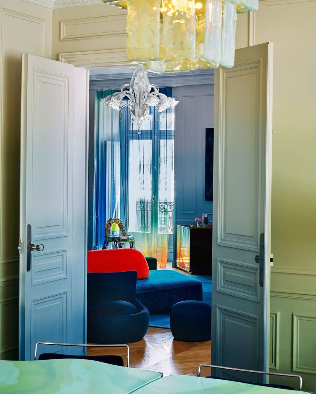 ELLE DECORさんのインスタグラム写真 - (ELLE DECORInstagram)「A young, worldly couple moved into a classic Haussmannian building near Paris’s Champs-Élysées and was faced with a choice: stay true to its 19th-century character or throw caution to the wind. One glance at its color-saturated rooms and it is evident which route this couple chose. They tapped French studio Uchronia (@uchronia_world) to douse the entire home in vivid colors. In the living and dining rooms, the designers deployed a custom dégradé wall treatment (a gradient color scale that, unlike ombré, allows for a range of hues) in mossy blue and green. “Where it was once banal,” the wife says, “it is now magic.”  Click the link in bio to tour the rest of this boundary-busting residence, as shown in our May 2023 issue. Written by @gaygassmann. Photographed by @felixdolmaillot.」5月4日 0時00分 - elledecor