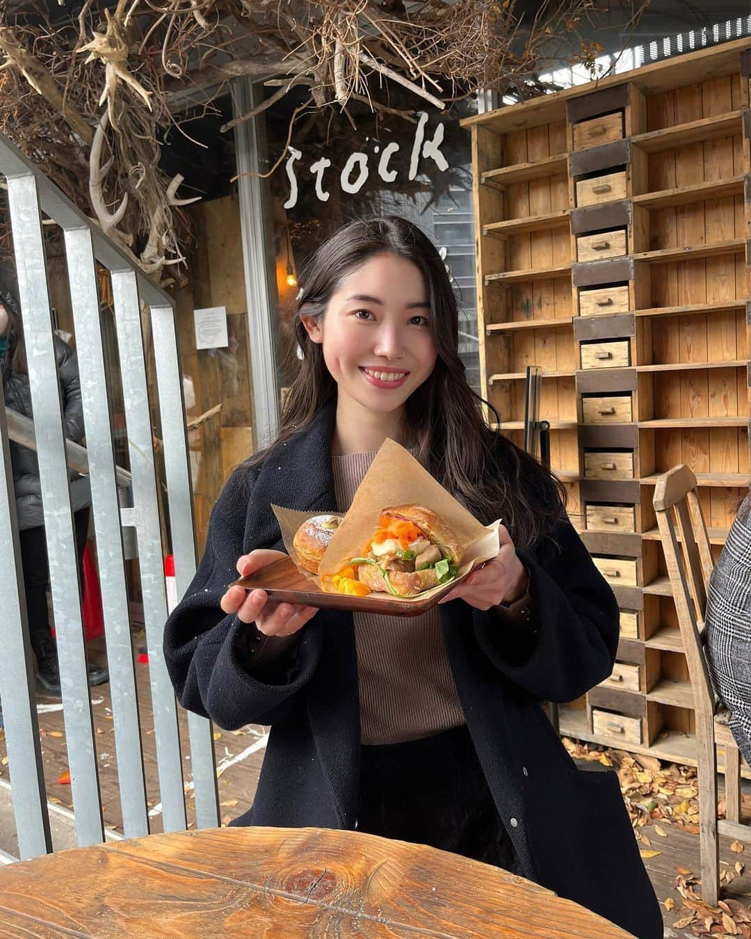 小川沙樹のインスタグラム：「📍stock 福岡旅行へ行った際に寄った大人気のパン屋さん🥖 雪が降る中1時間外で並びました。 そして席も外で雪に吹雪かれながら食べていたので手が真っ赤❄️ でも味は本当に美味しくて並んで後悔はしていないです！ 私のおすすめは写真の手前の「オレンジキャロットラペとチキンソテーヨーグルトソースのサンド」」